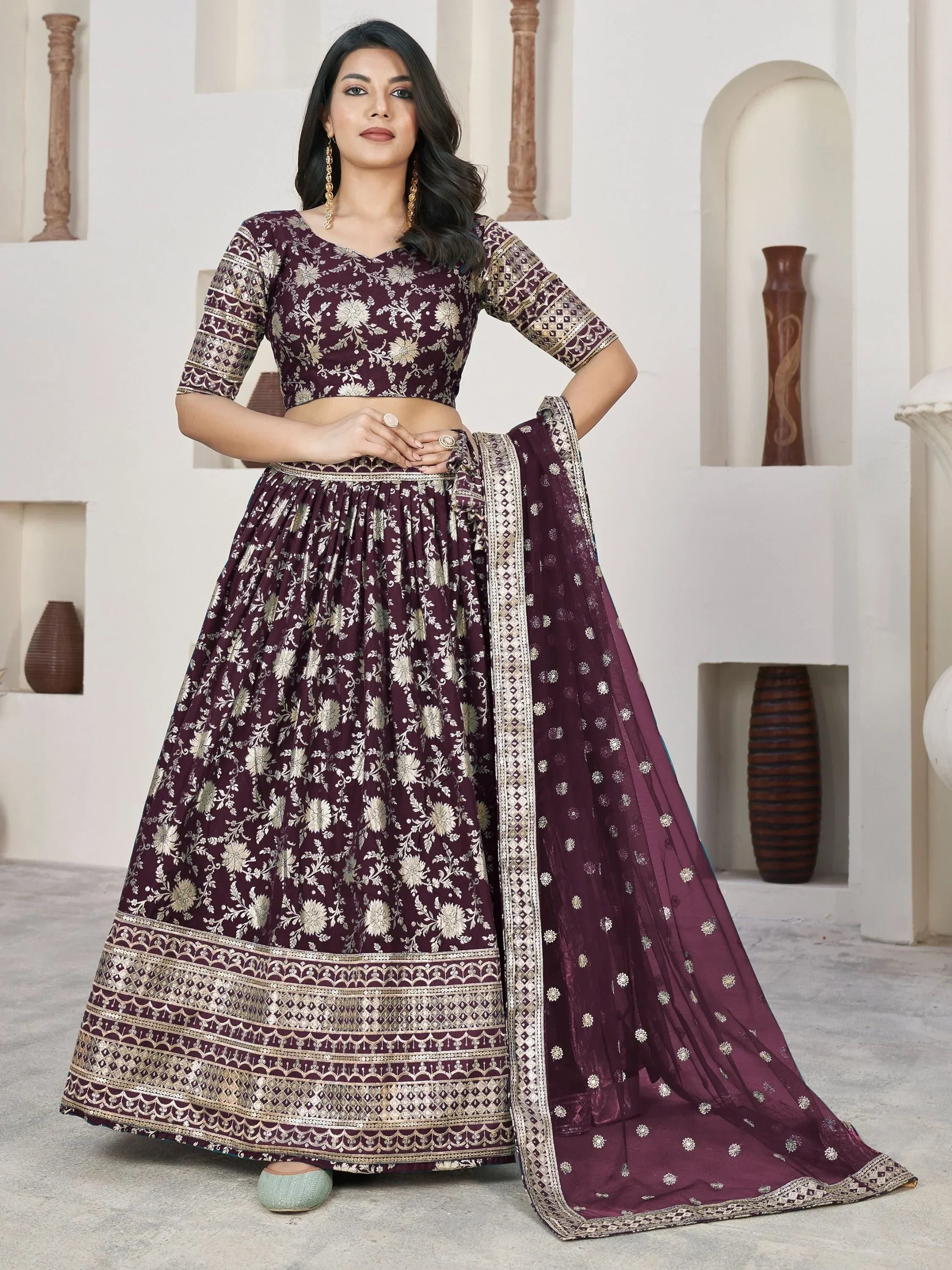 Elegant maroon lehenga choli with gold floral embroidery and dupatta, perfect for Indian ethnic occasions.
