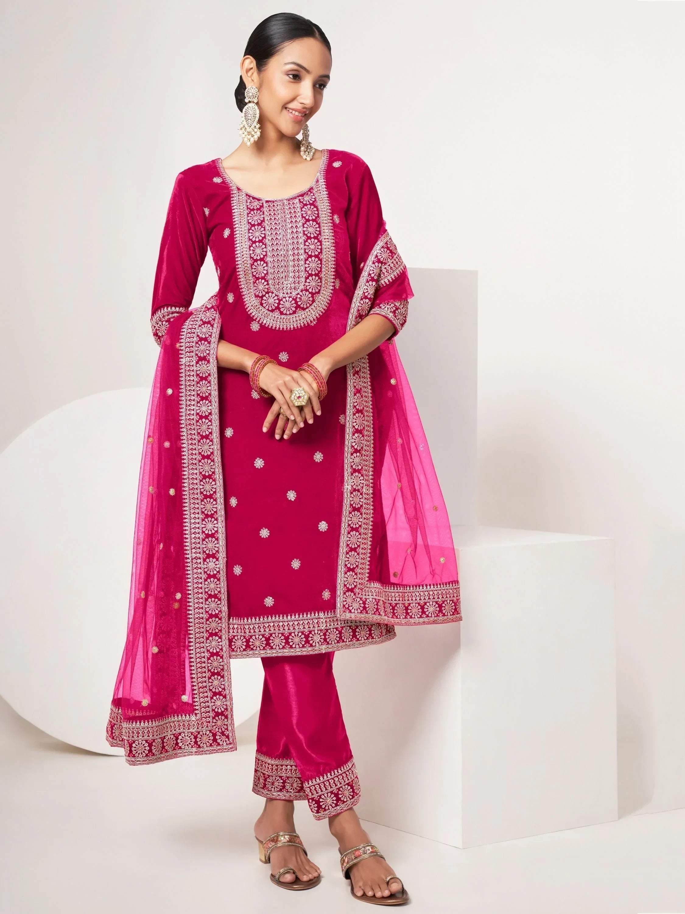 Woman in magenta embroidered salwar kameez with chiffon dupatta and statement earrings