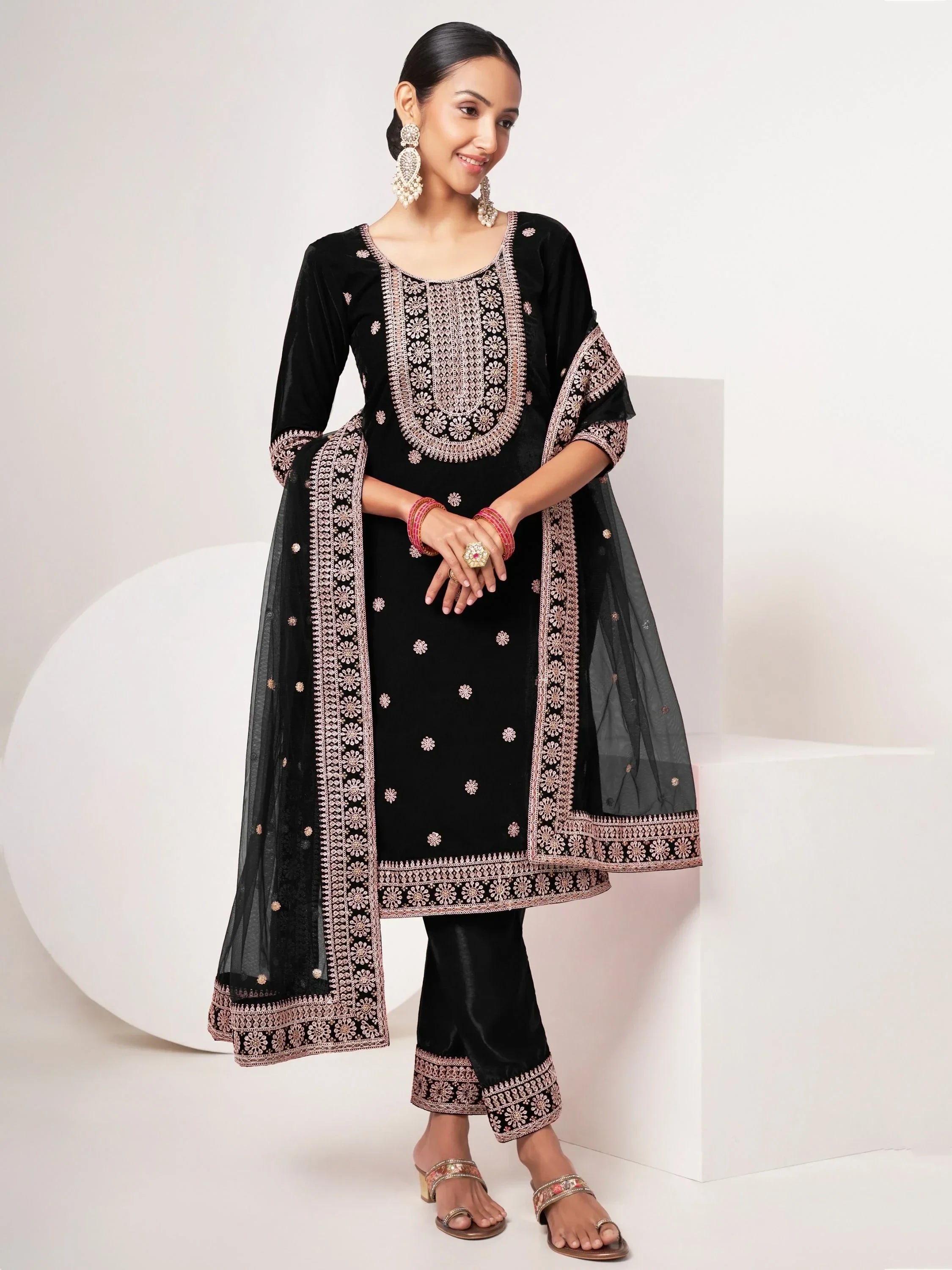 Woman wearing a black embroidered salwar kameez with matching dupatta and ethnic jewelry