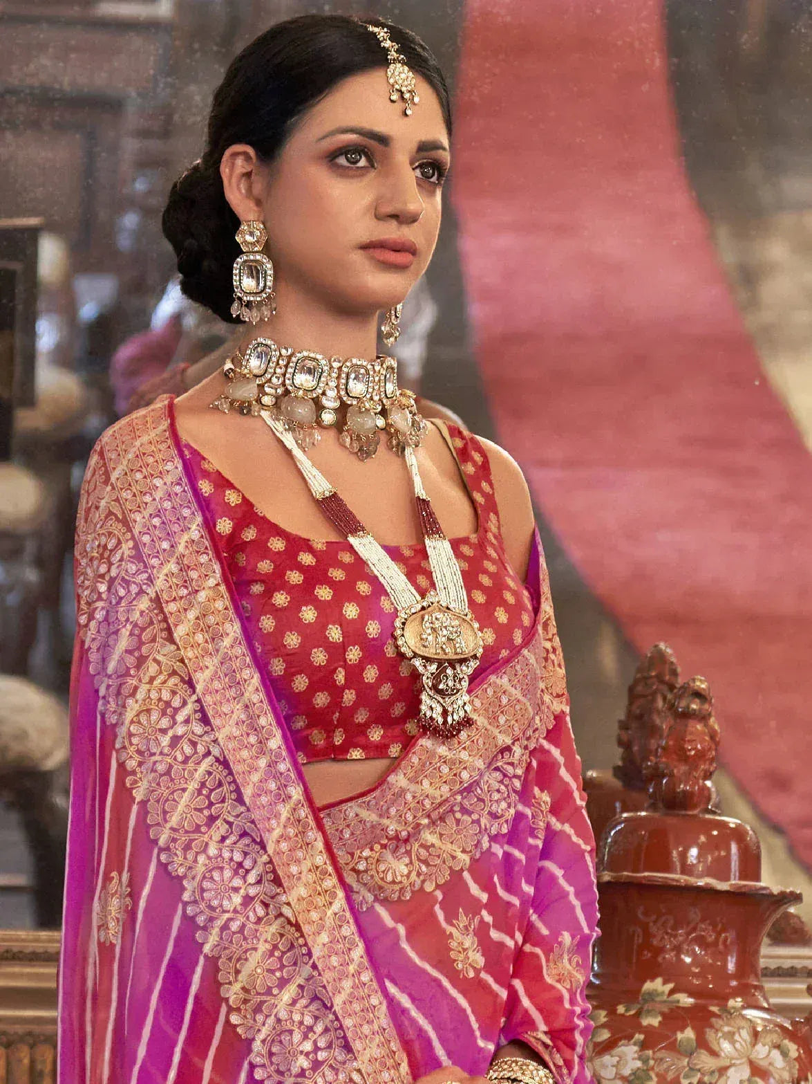 Elegant woman in pink and gold embroidered lehenga choli with traditional Indian jewelry