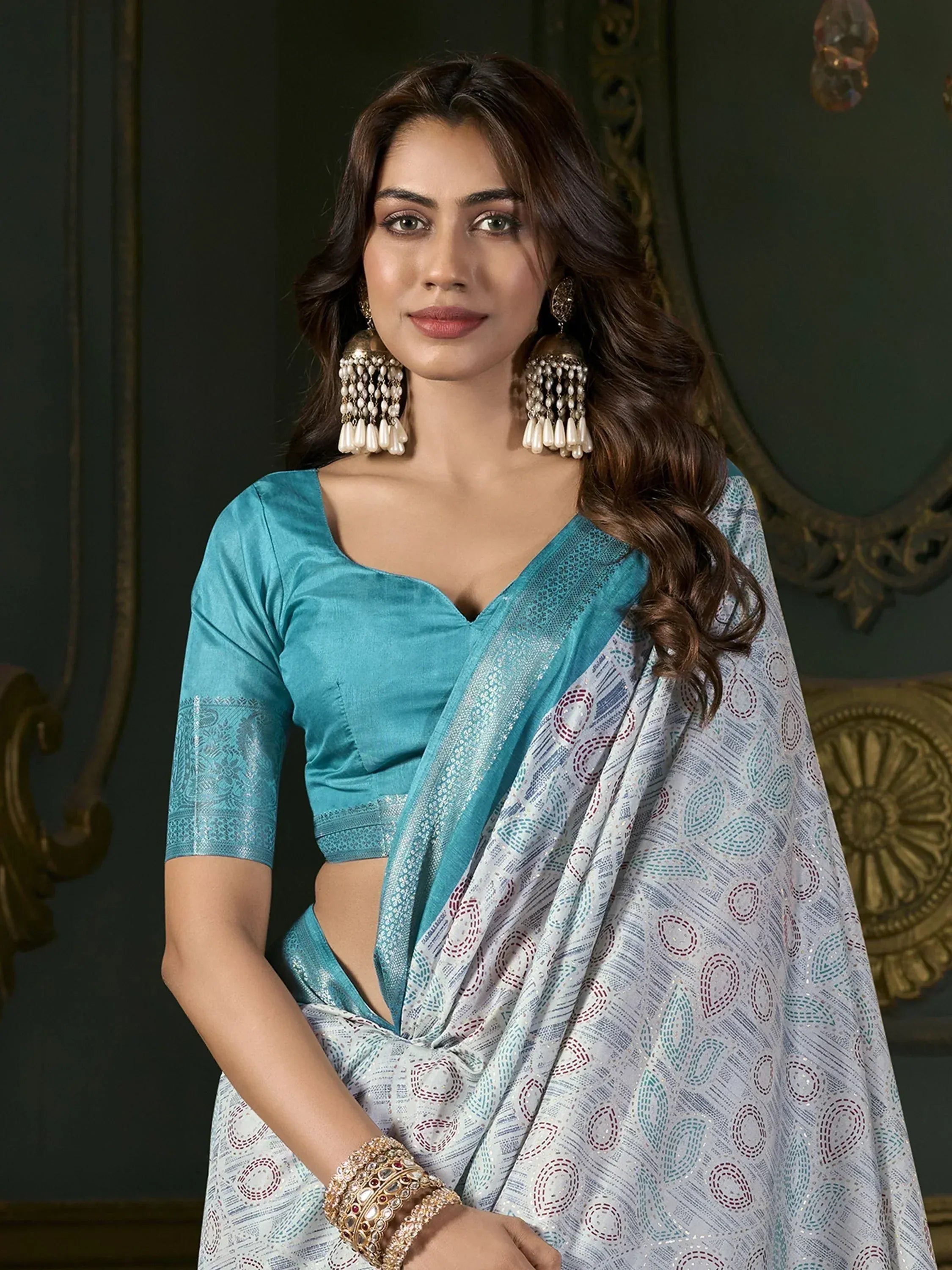 Woman in elegant white and teal printed saree with matching blouse, perfect for Indian ethnic occasions.
