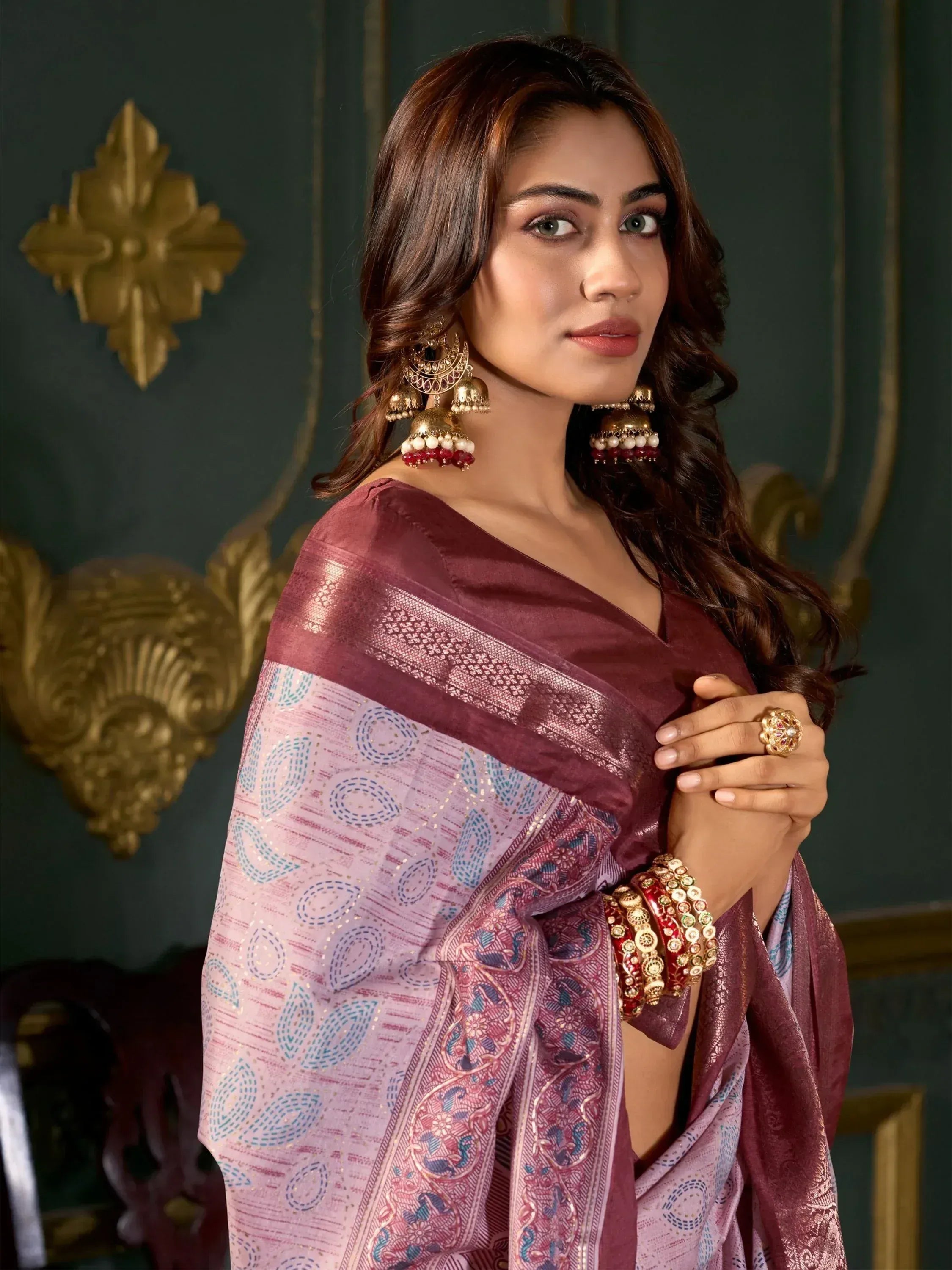 Woman in maroon and pink printed saree with gold jewelry, elegant ethnic wear for festive occasions