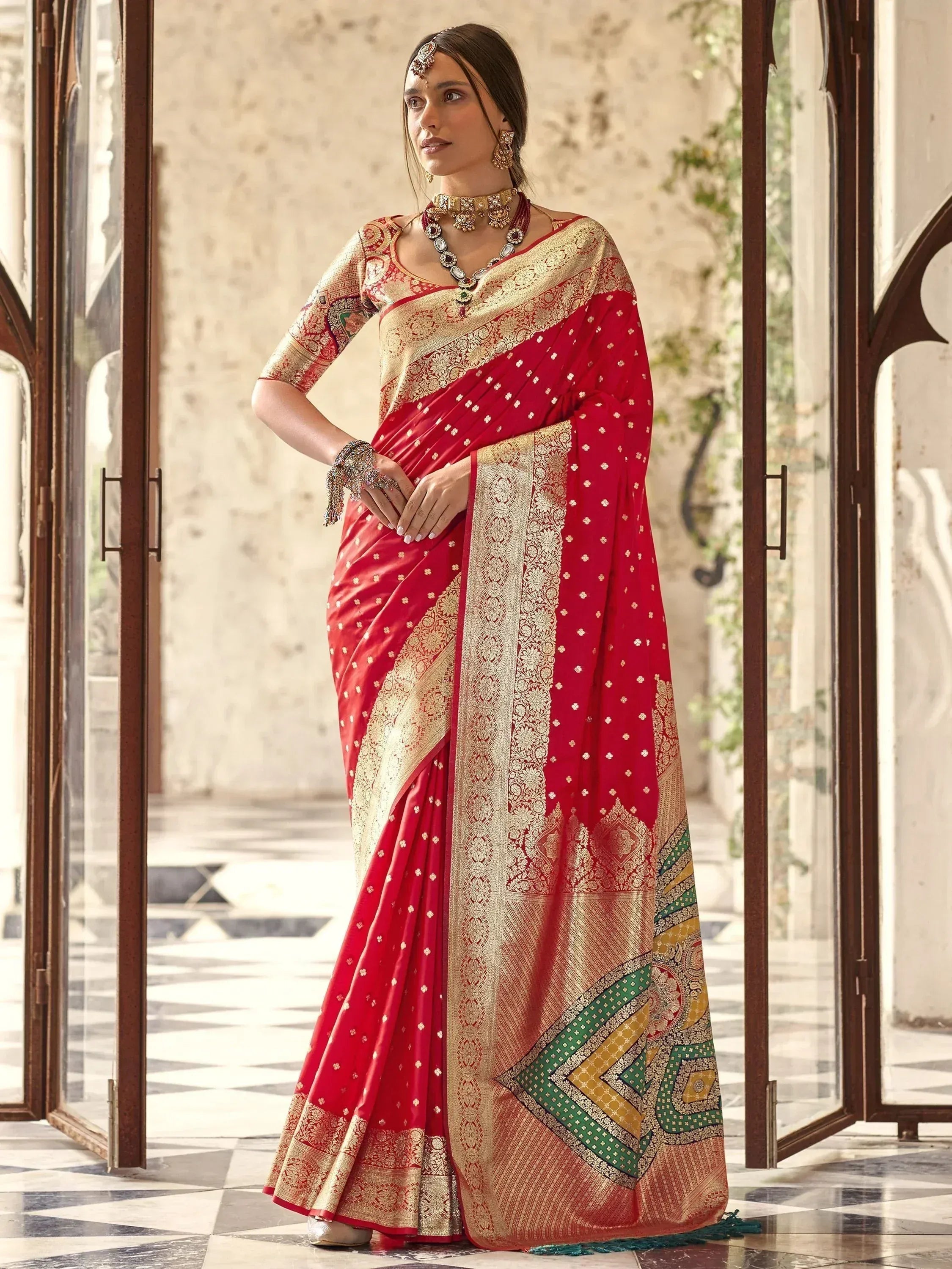 Red and gold designer saree with intricate embroidery and traditional jewelry for Indian ethnic wear