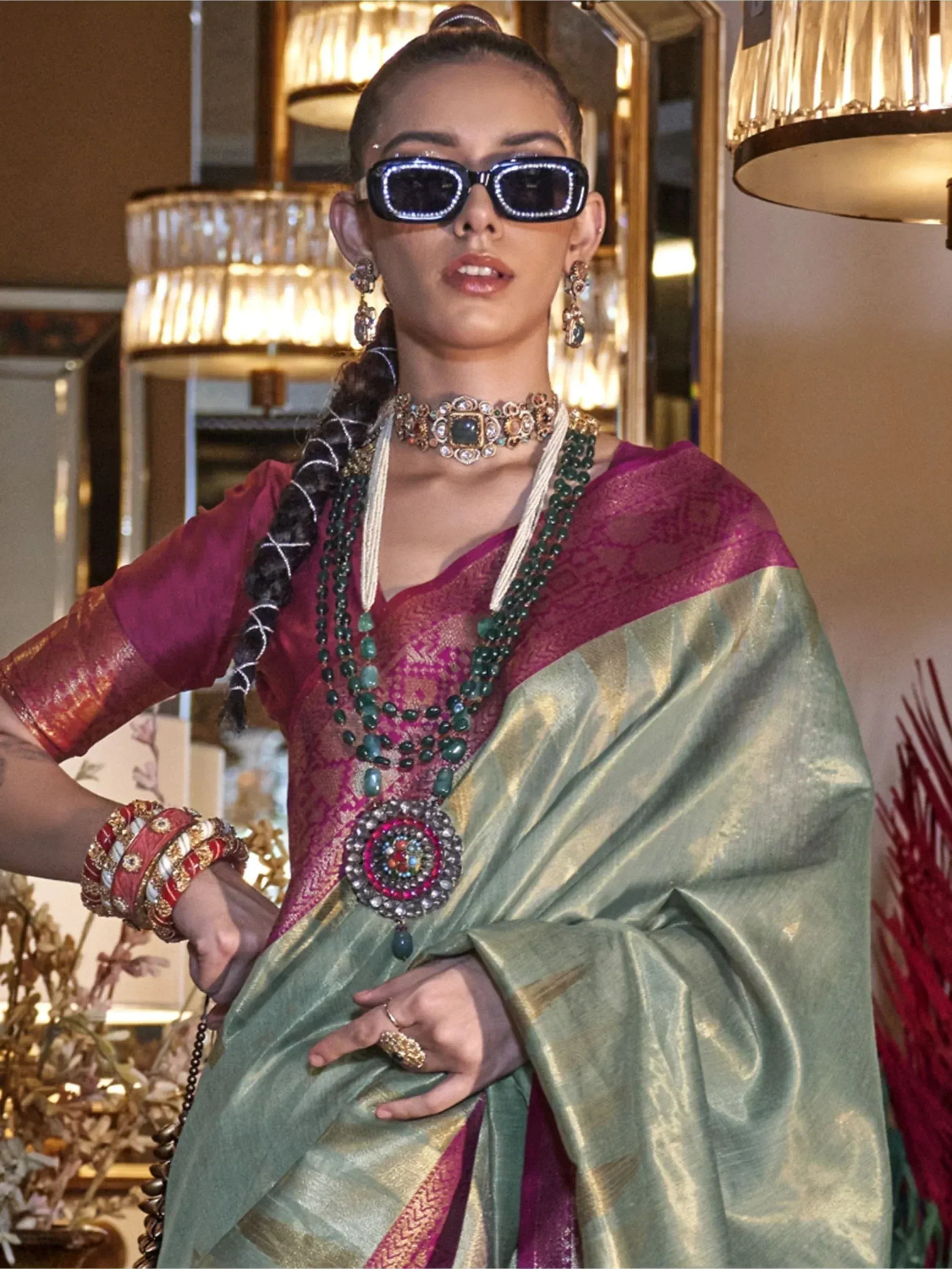 Woman in purple and green designer saree with heavy jewelry and sunglasses, ethnic wear fashion