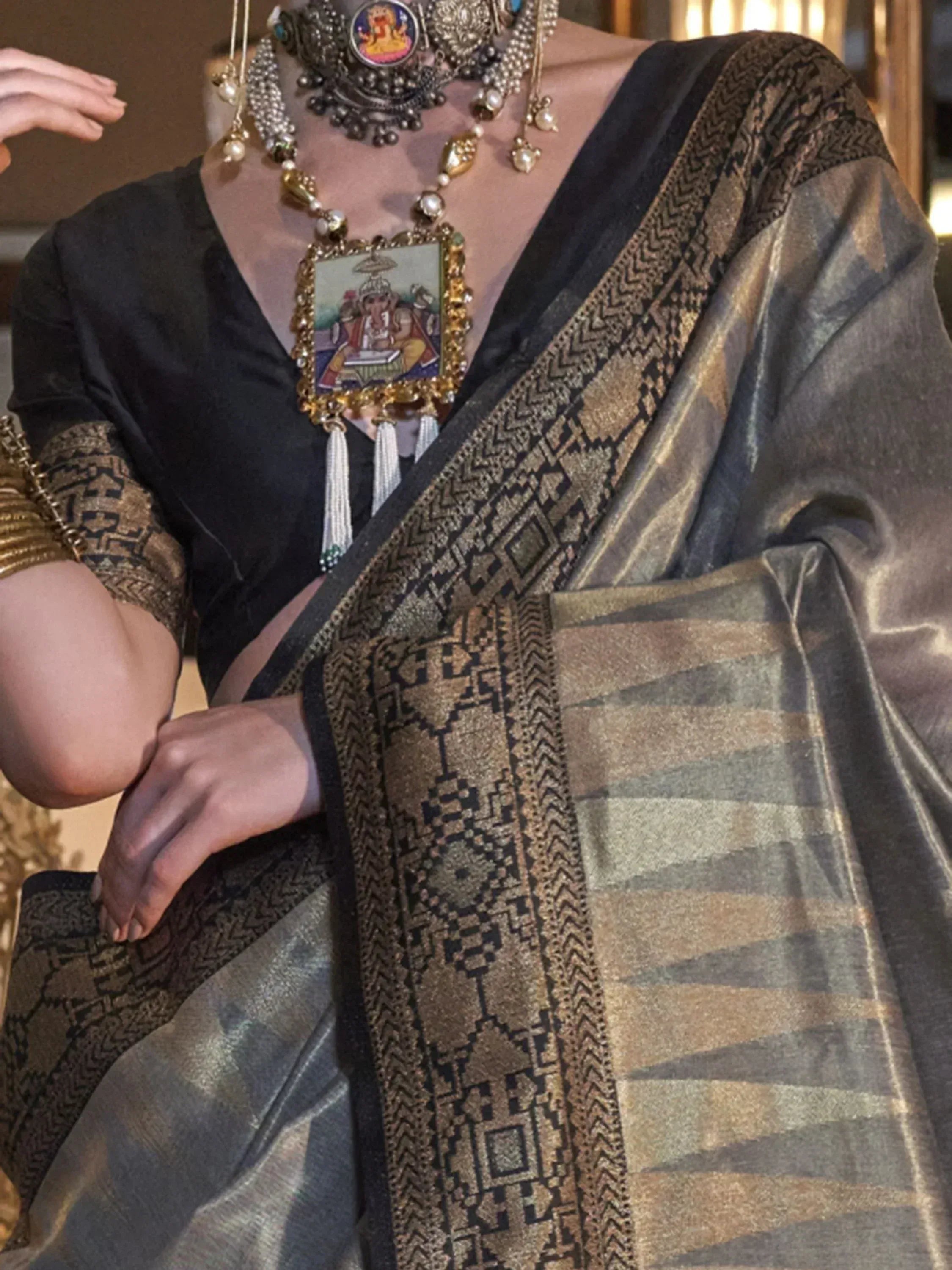 Black and gold ethnic saree with intricate geometric border and traditional temple jewelry