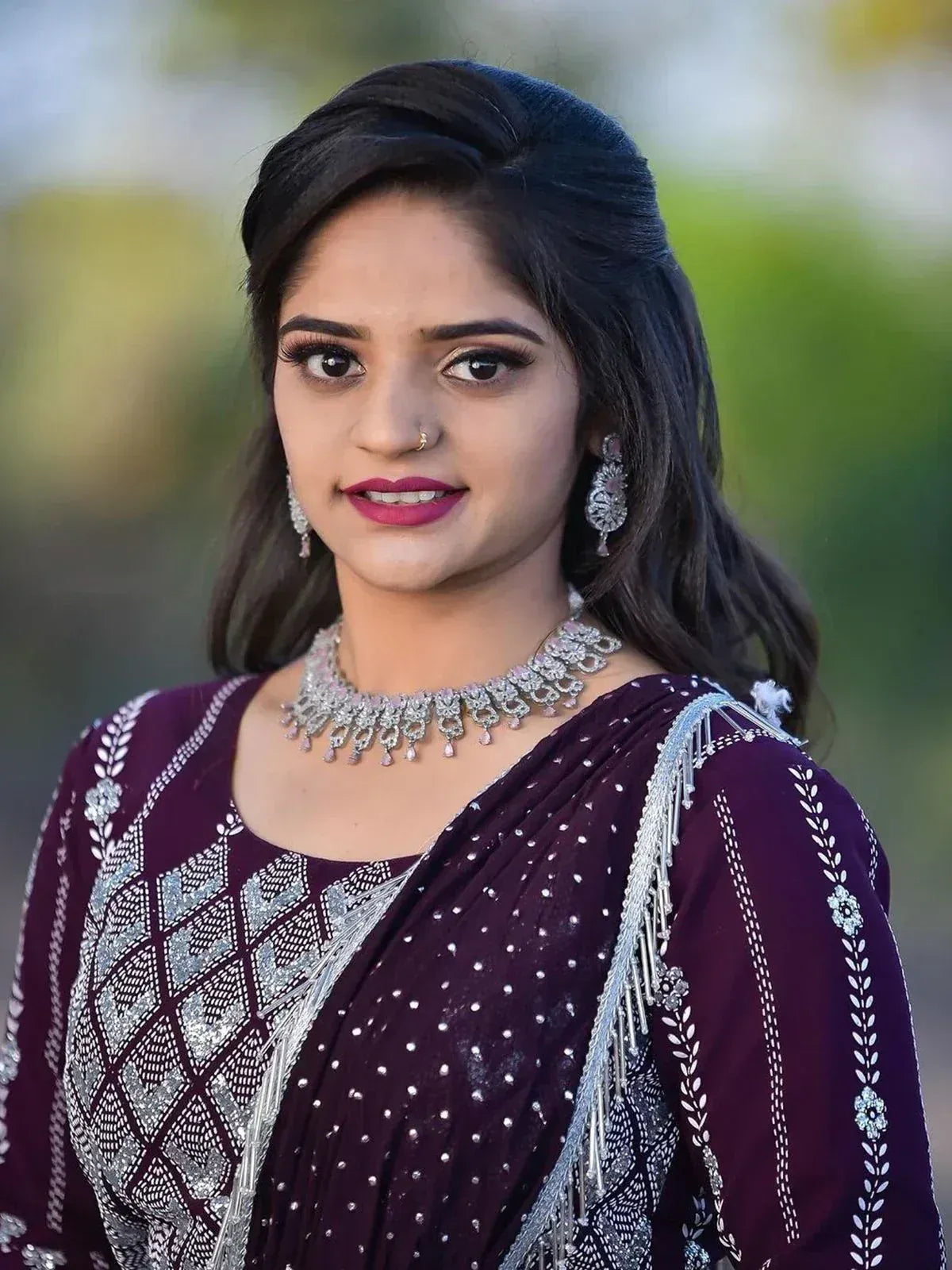 Woman in maroon ethnic saree with silver embroidery and jewelry, perfect for Indian occasions