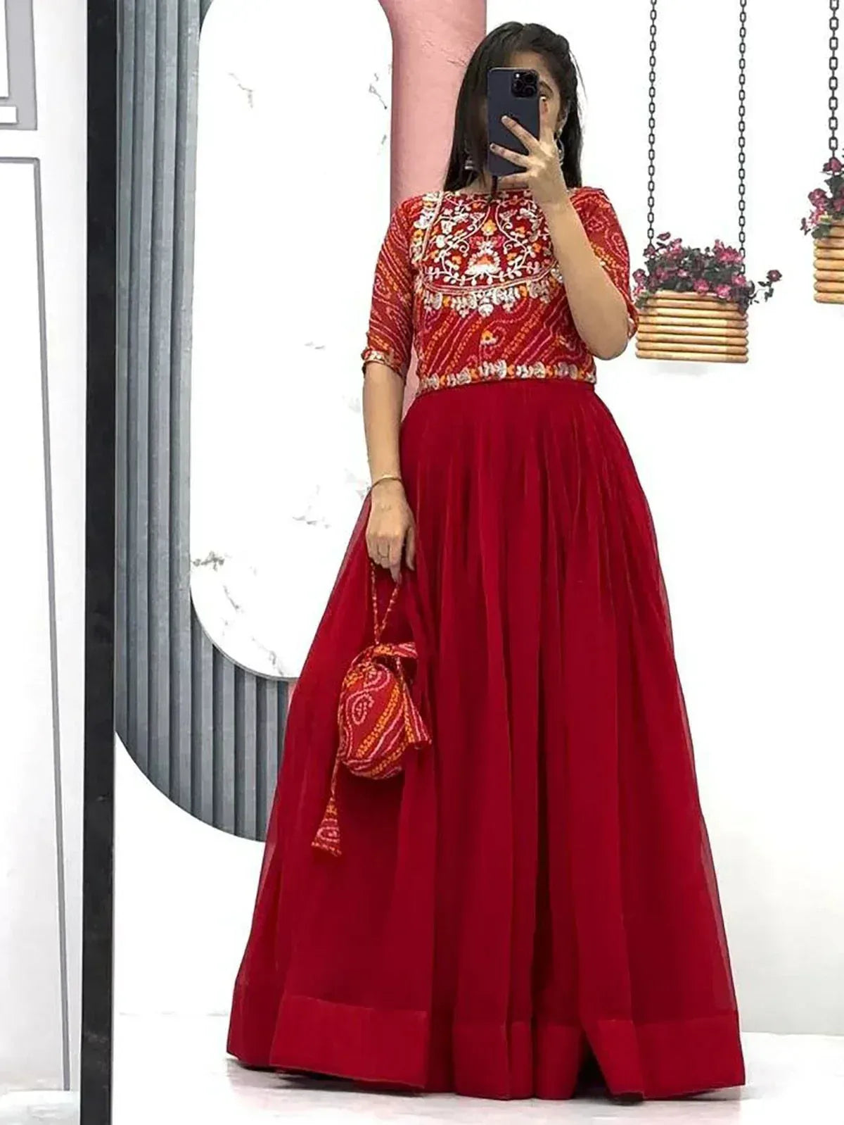 Red embroidered ethnic gown with matching potli bag, perfect for Indian festive occasions