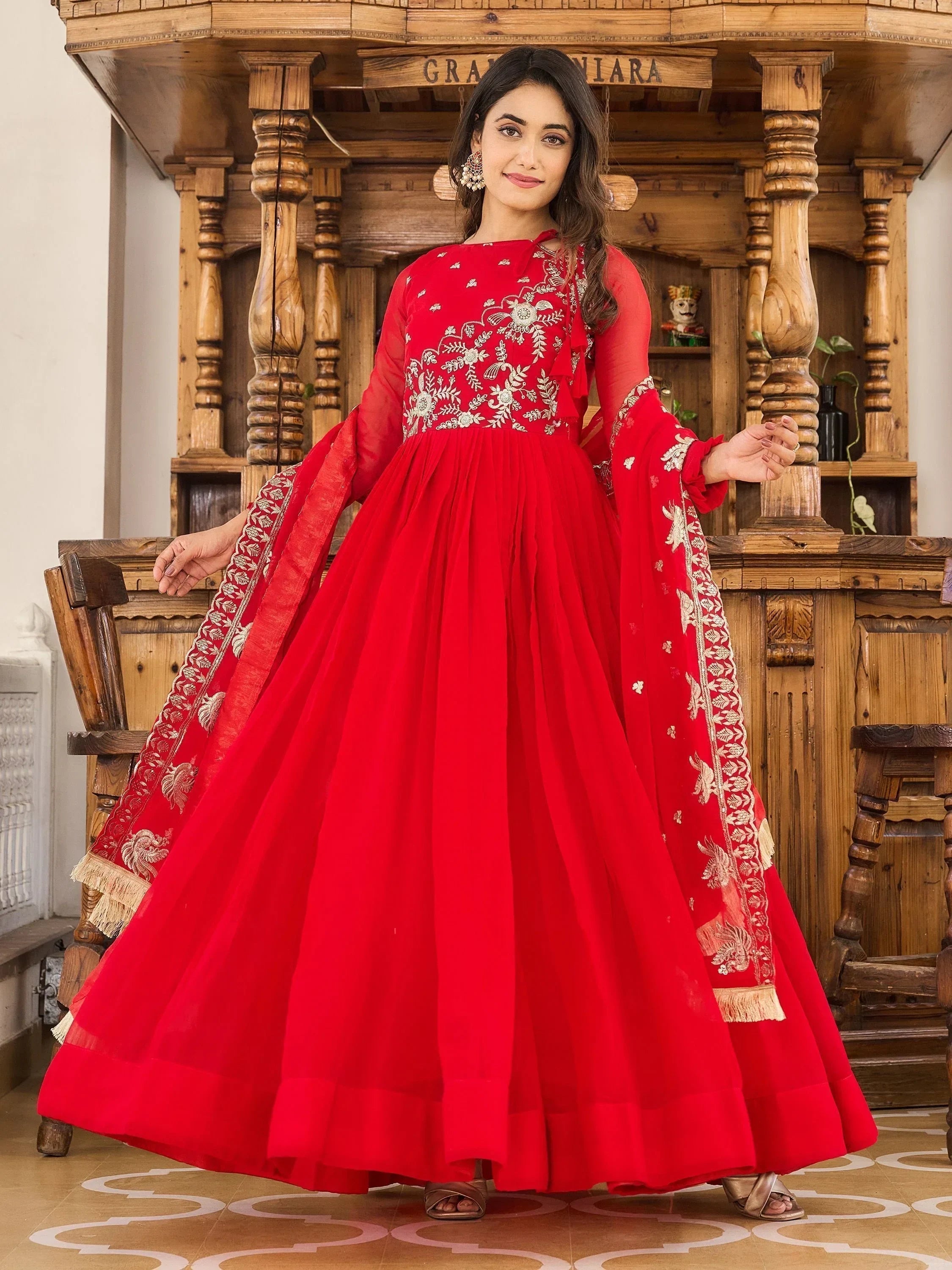Woman in a red embroidered Anarkali gown with dupatta, traditional Indian ethnic wear