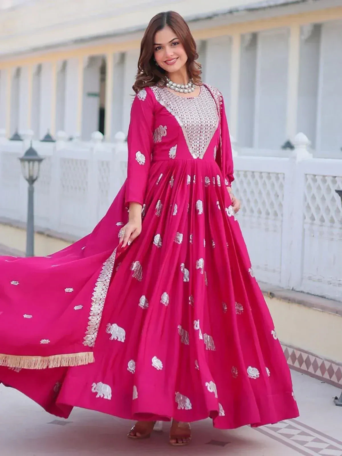 Pink ethnic gown with silver elephant embroidery and lace detailing, perfect for festive occasions
