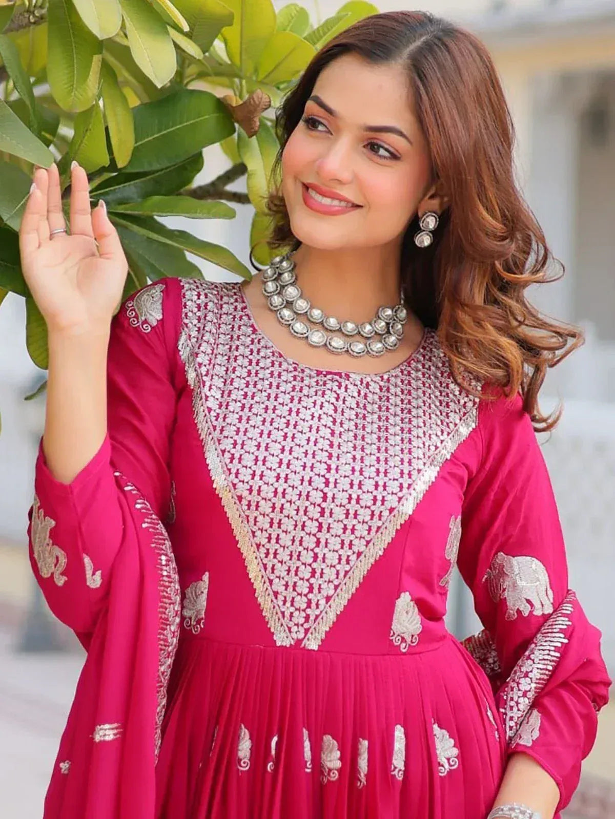 Woman in pink ethnic gown with silver embroidery and elephant motifs, styled with statement jewelry