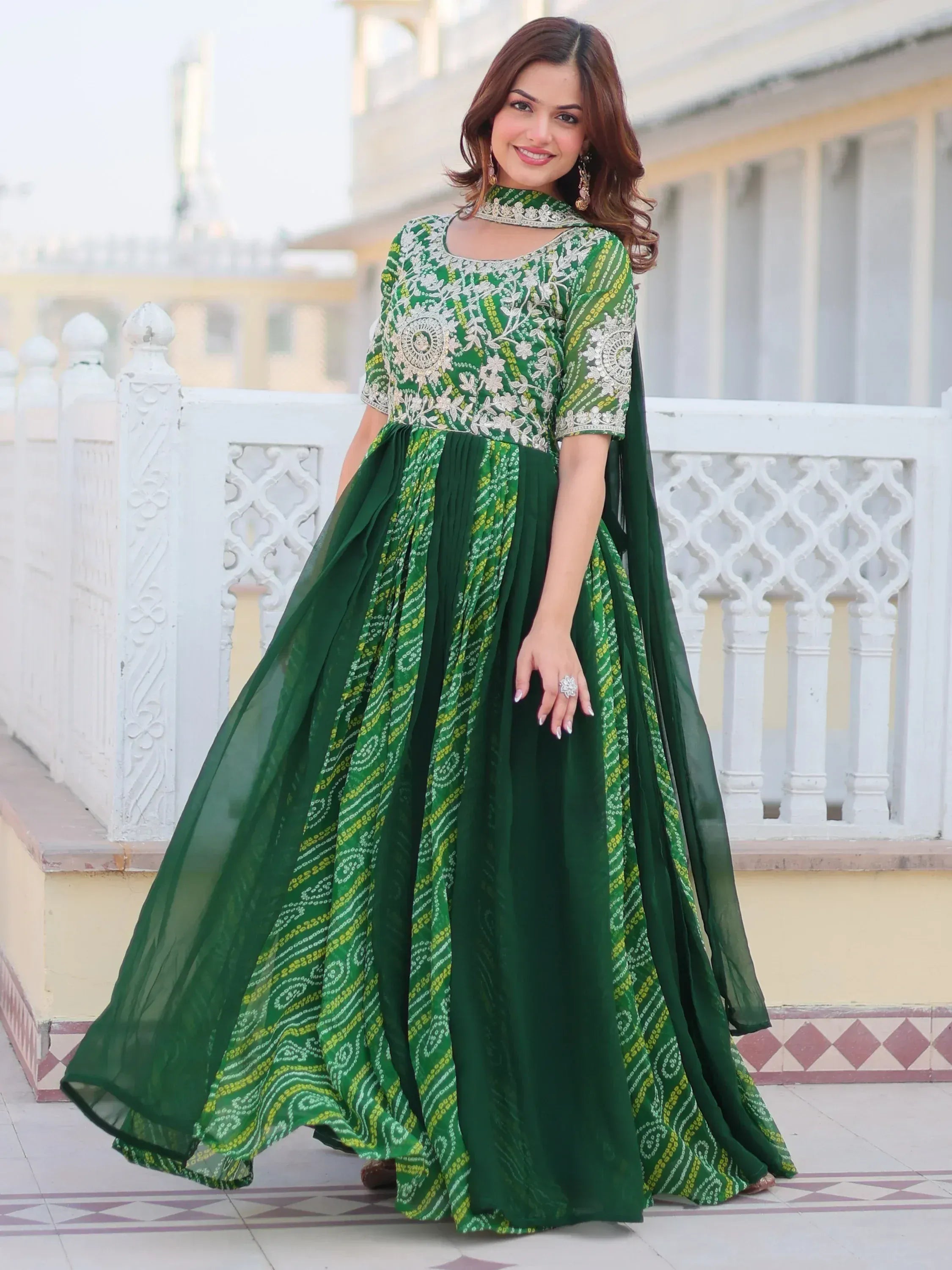 Elegant green ethnic gown with floral embroidery and paisley print, perfect for Indian festive occasions.