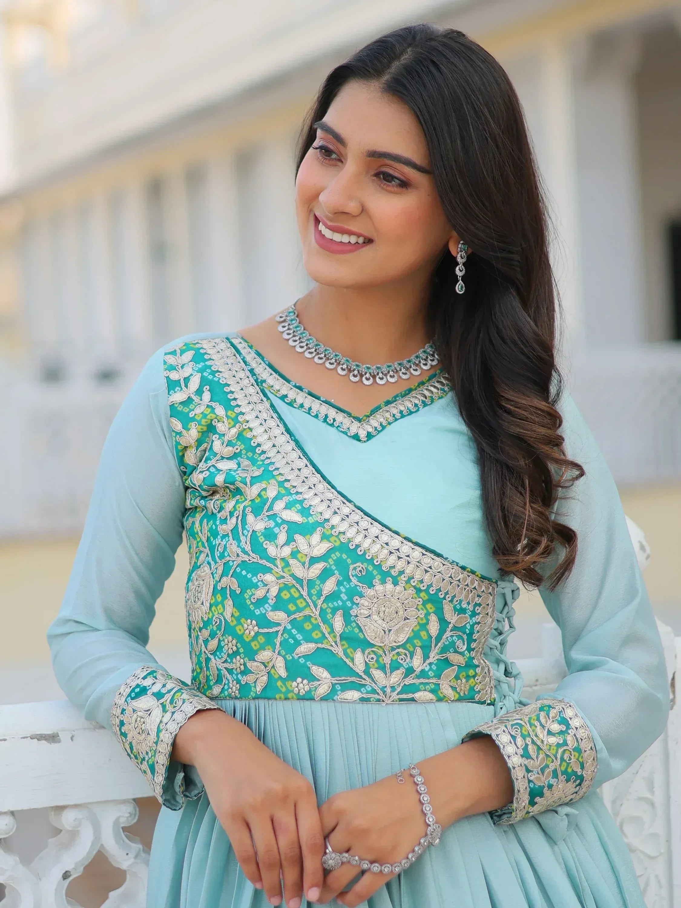 Woman in light blue embroidered ethnic gown with floral patterns, perfect for Indian occasions and festive wear.