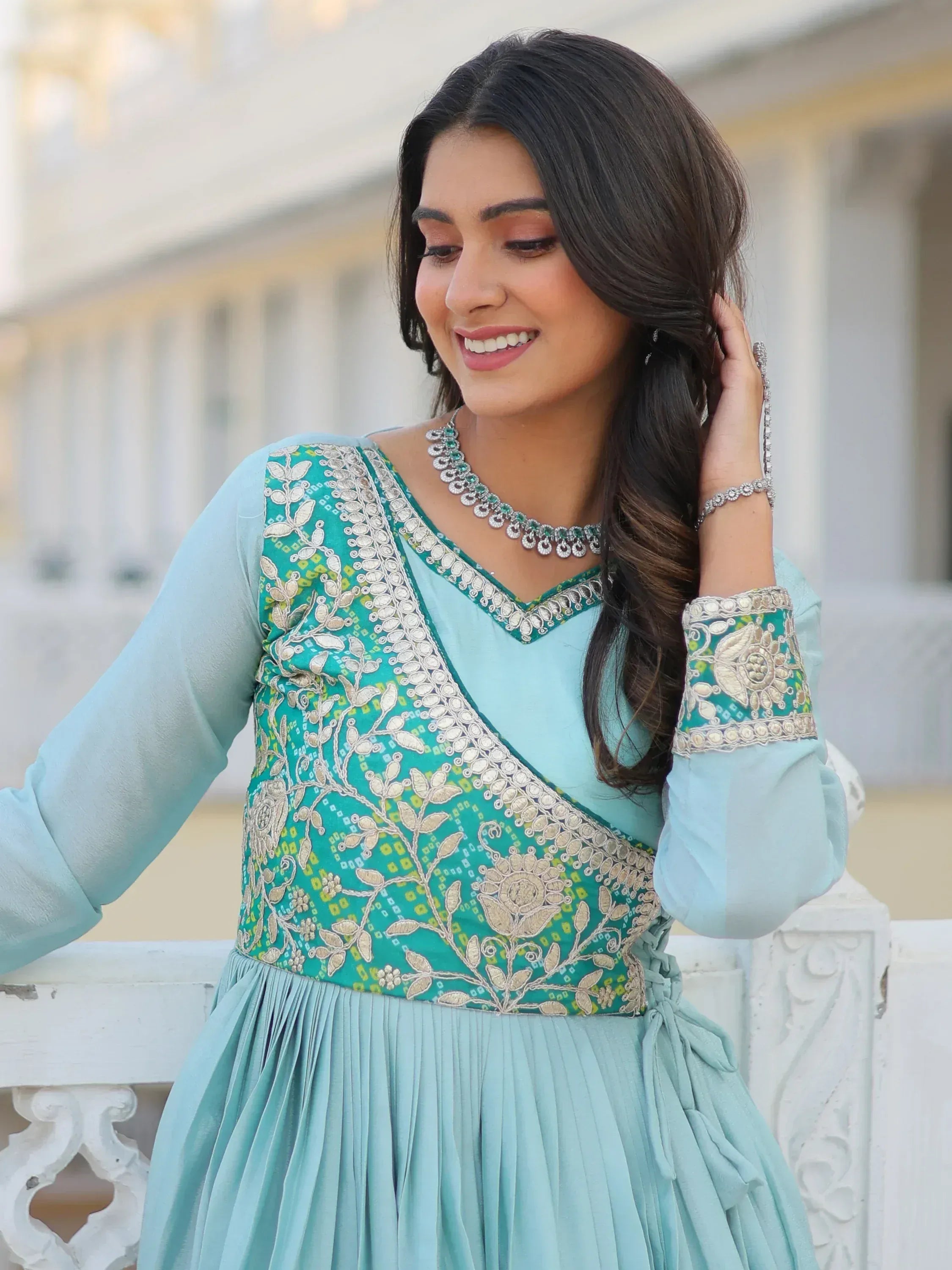 Woman in light blue embroidered ethnic gown with floral detailing, perfect for Indian occasions