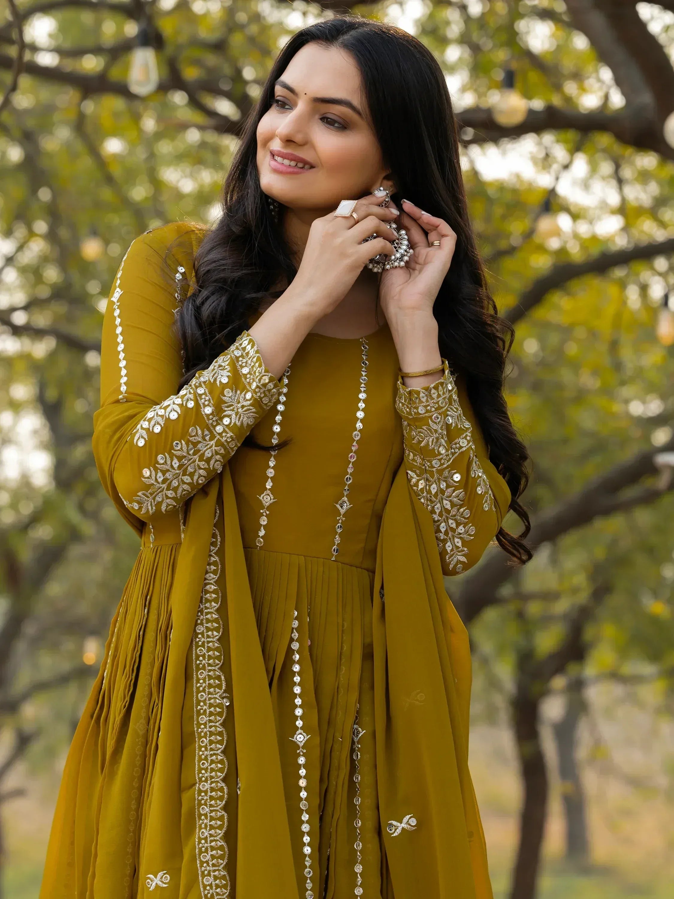 Woman in mustard yellow embroidered ethnic gown with mirror work, perfect for Indian occasions