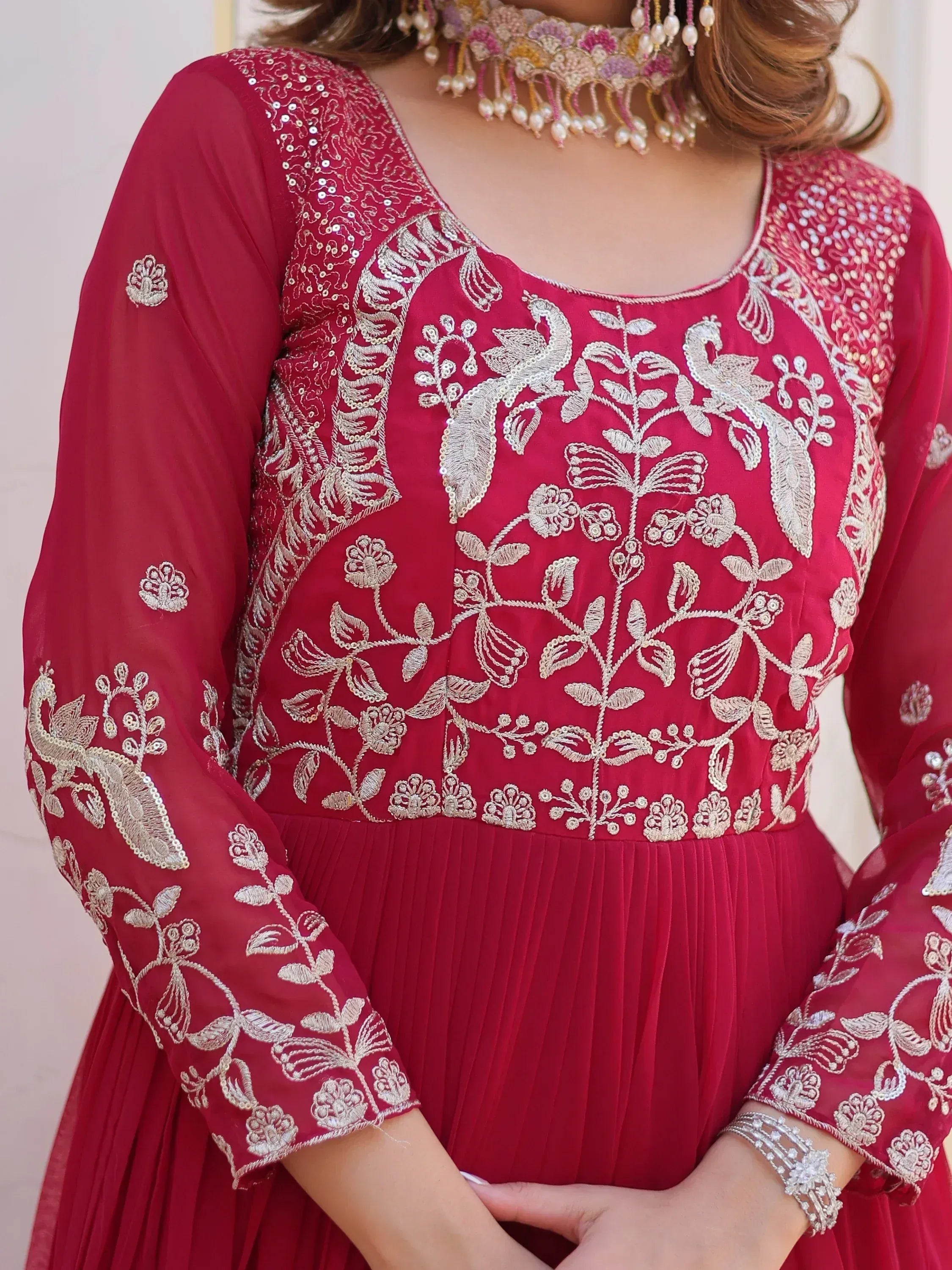 Red ethnic gown with silver peacock embroidery, perfect for Indian weddings and festive occasions.