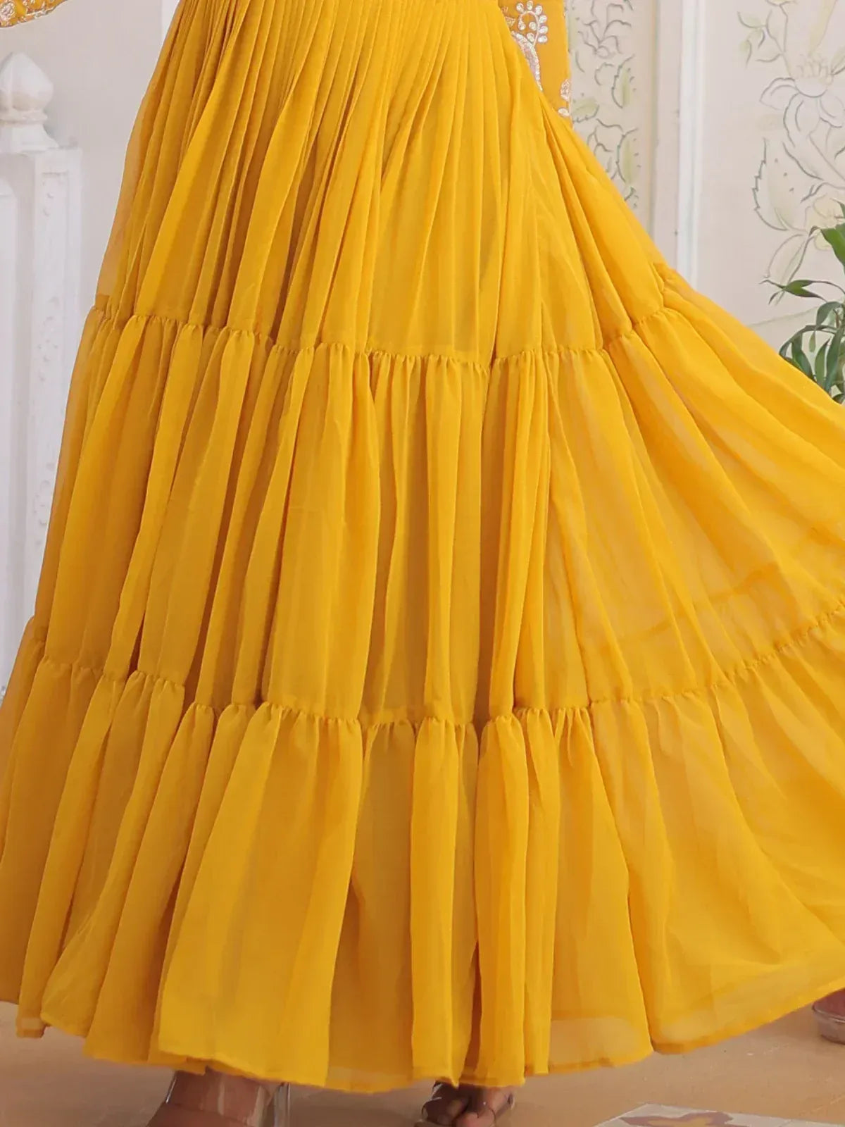 Vibrant yellow pleated ethnic gown with layered ruffles, perfect for festive occasions