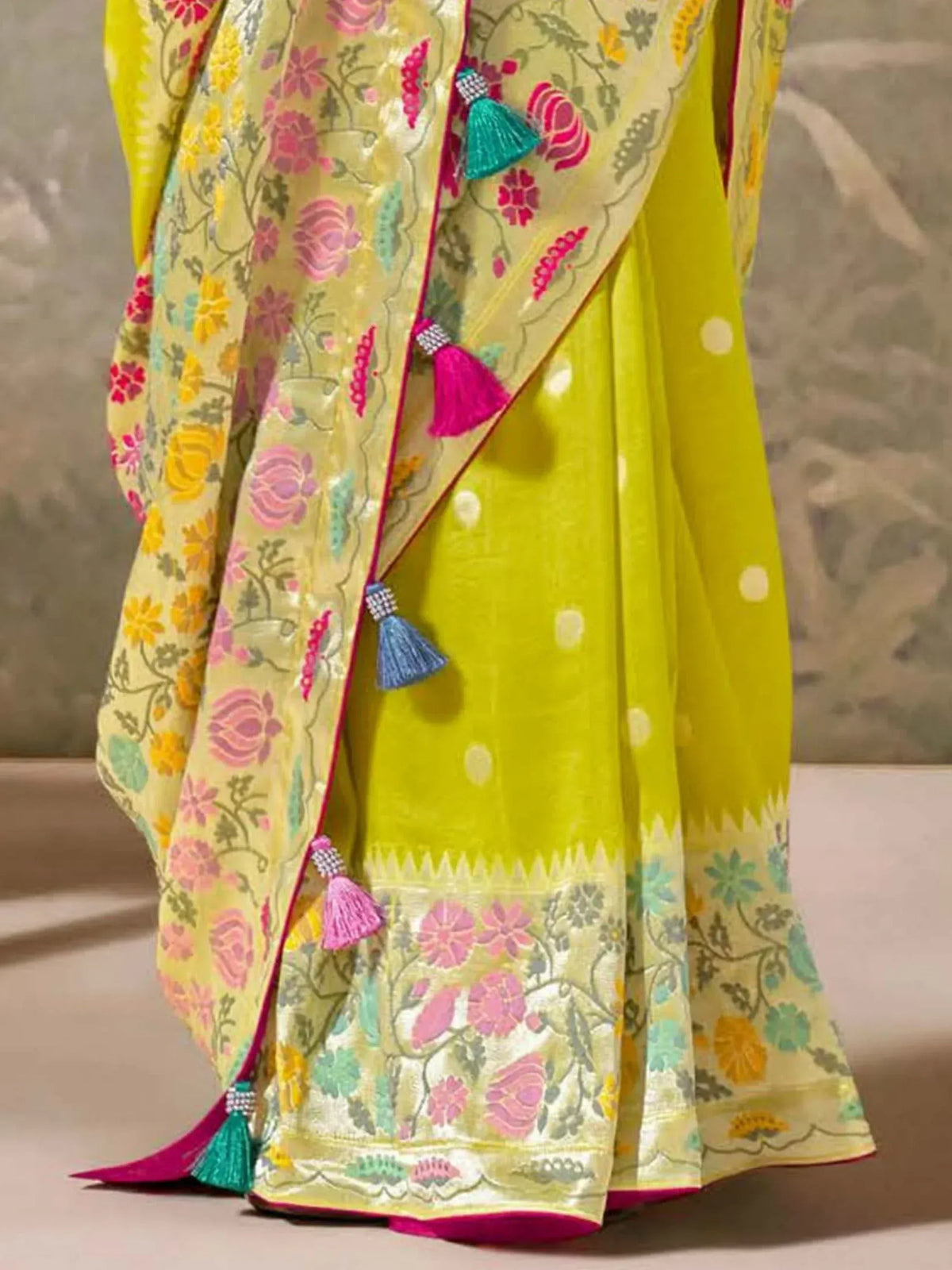 Vibrant yellow floral saree with tassels, perfect for Indian ethnic wear and festive occasions.