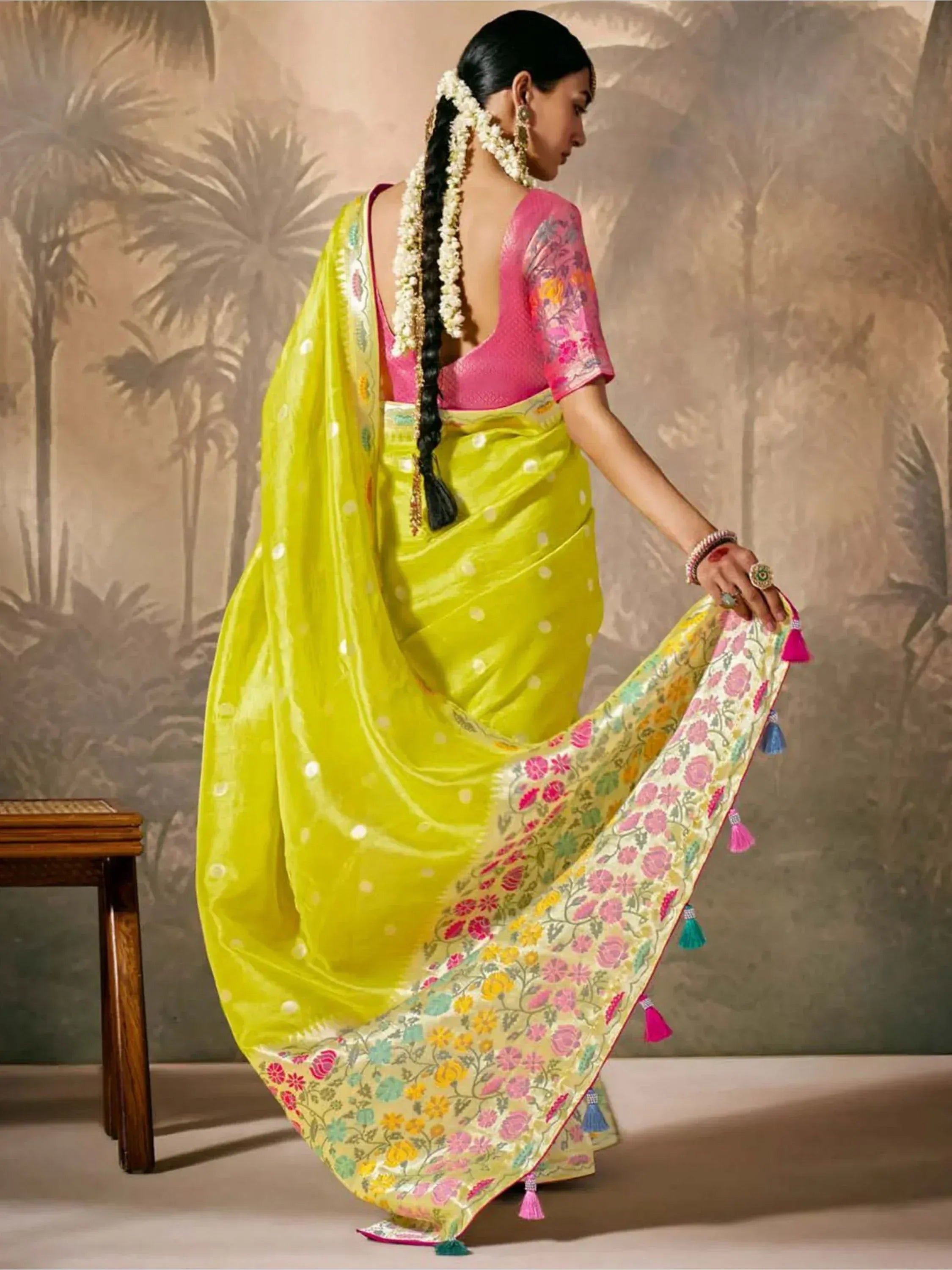 Vibrant yellow saree with floral border and tassels, paired with pink blouse, perfect for Indian ethnic occasions.