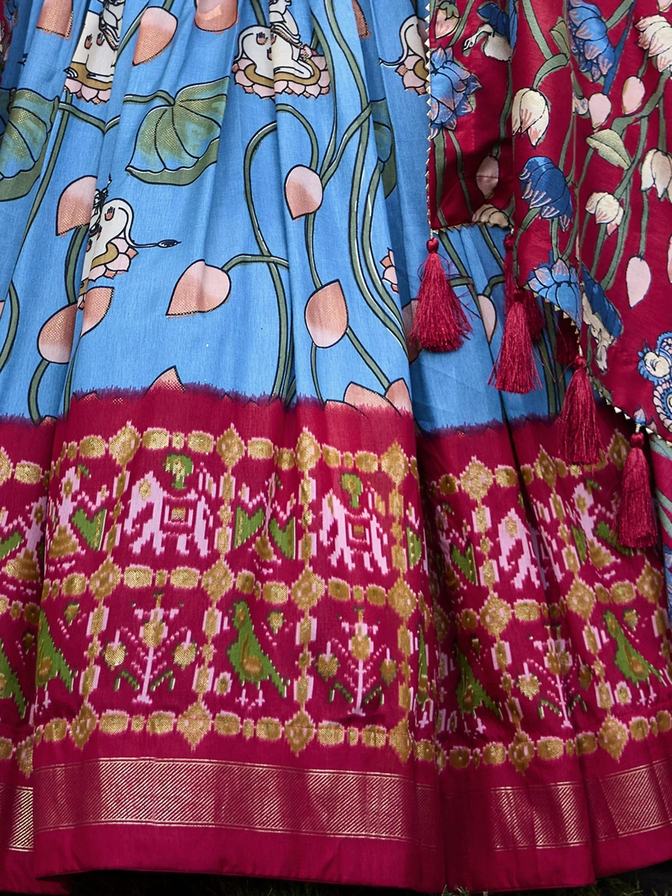 Blue and red ethnic lehenga skirt with floral Ganesha print and ikat border, tassels detail