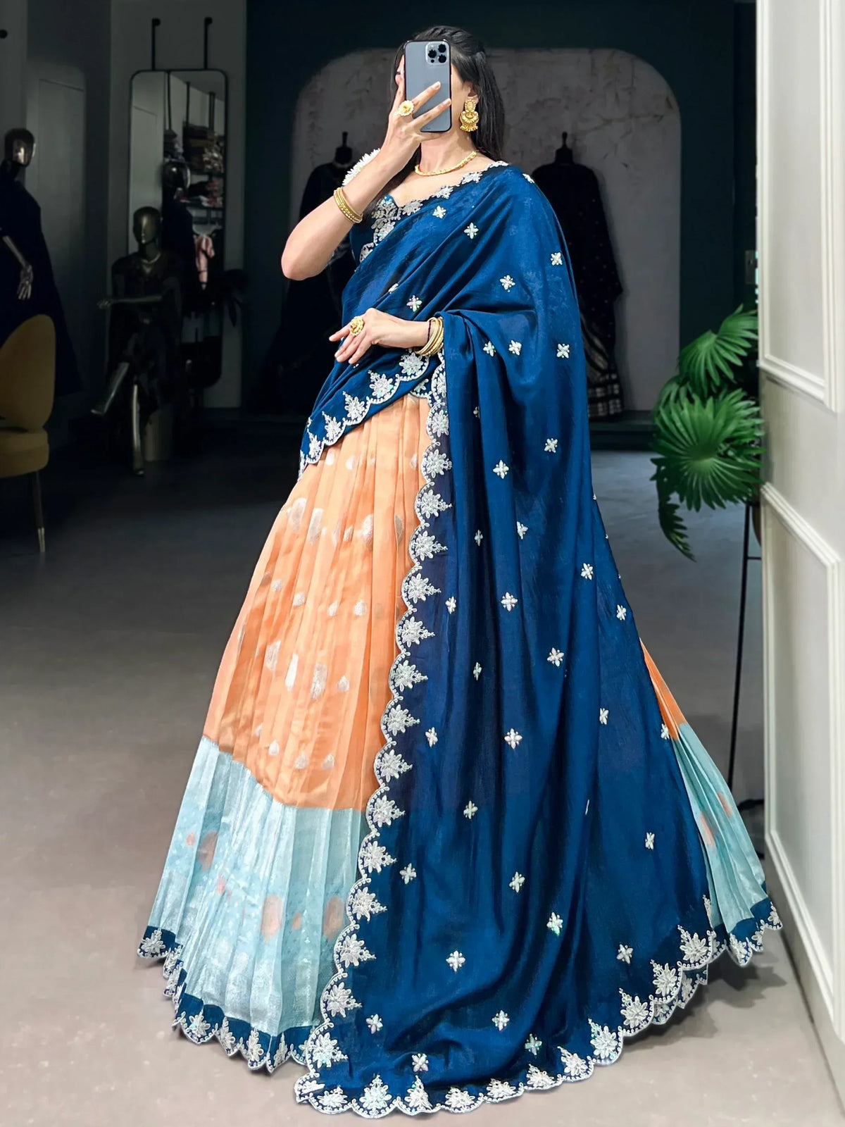Woman in blue and peach embroidered lehenga choli with floral detailing, perfect for Indian ethnic wear occasions