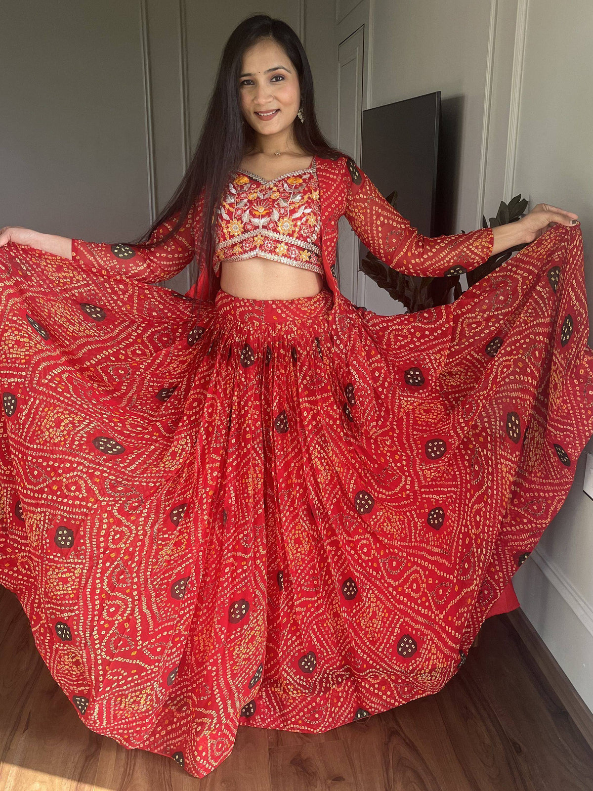 Woman in red printed lehenga choli with floral embroidery, showcasing ethnic Indian wear
