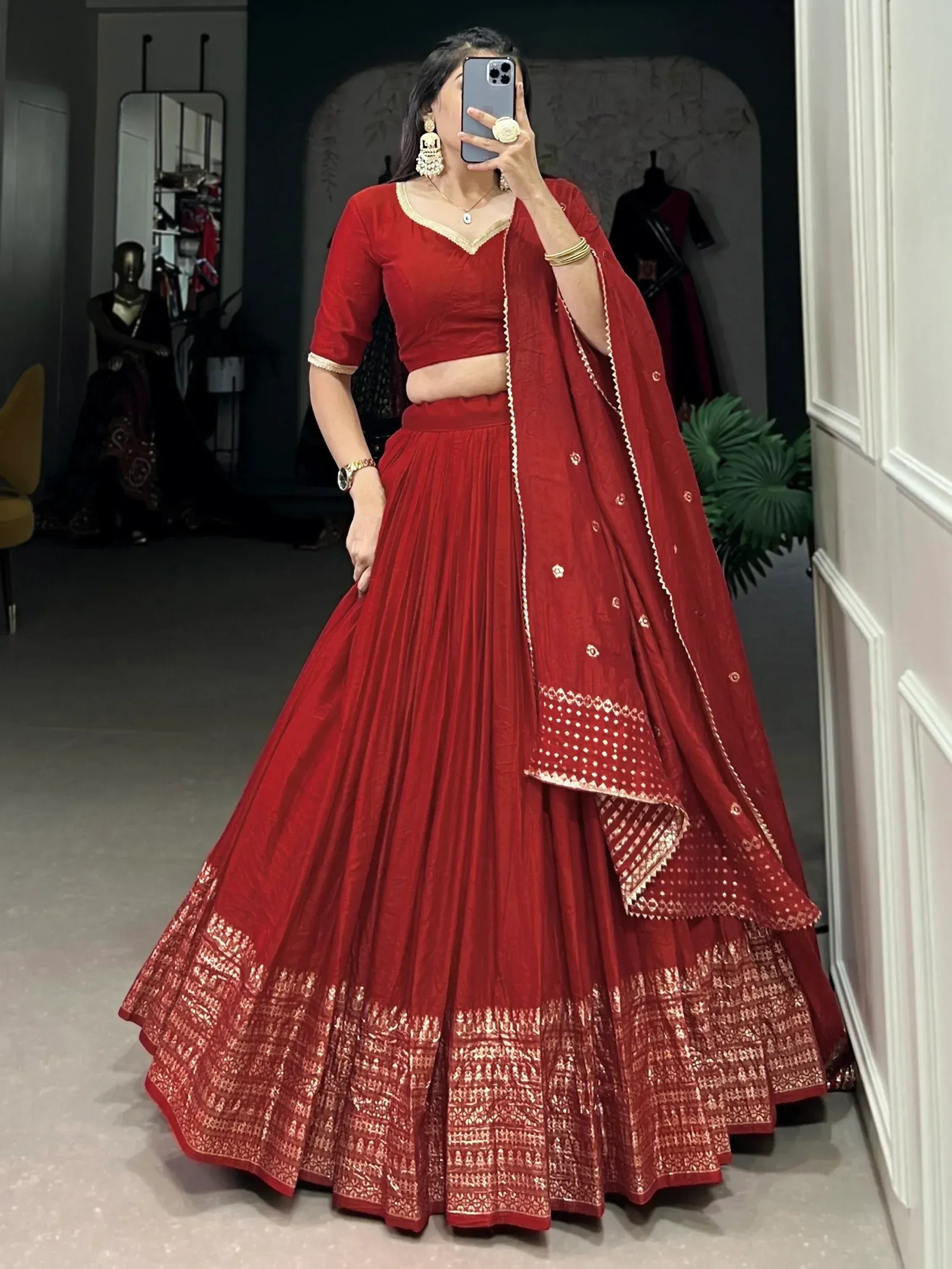 Red designer lehenga choli with gold embroidery, perfect for Indian weddings and festive occasions.
