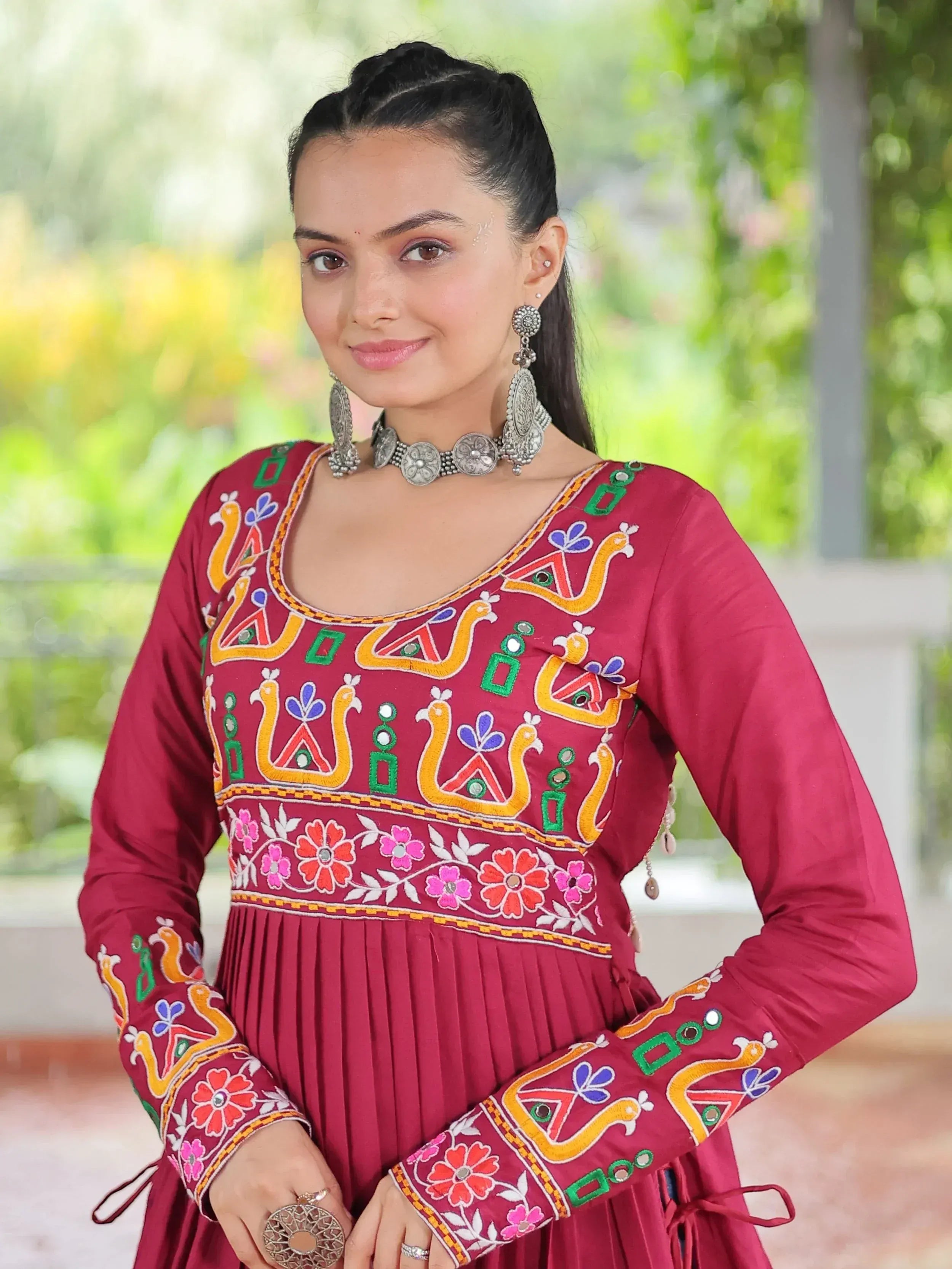 Maroon ethnic kurti with colorful peacock embroidery and floral patterns, paired with silver jewelry