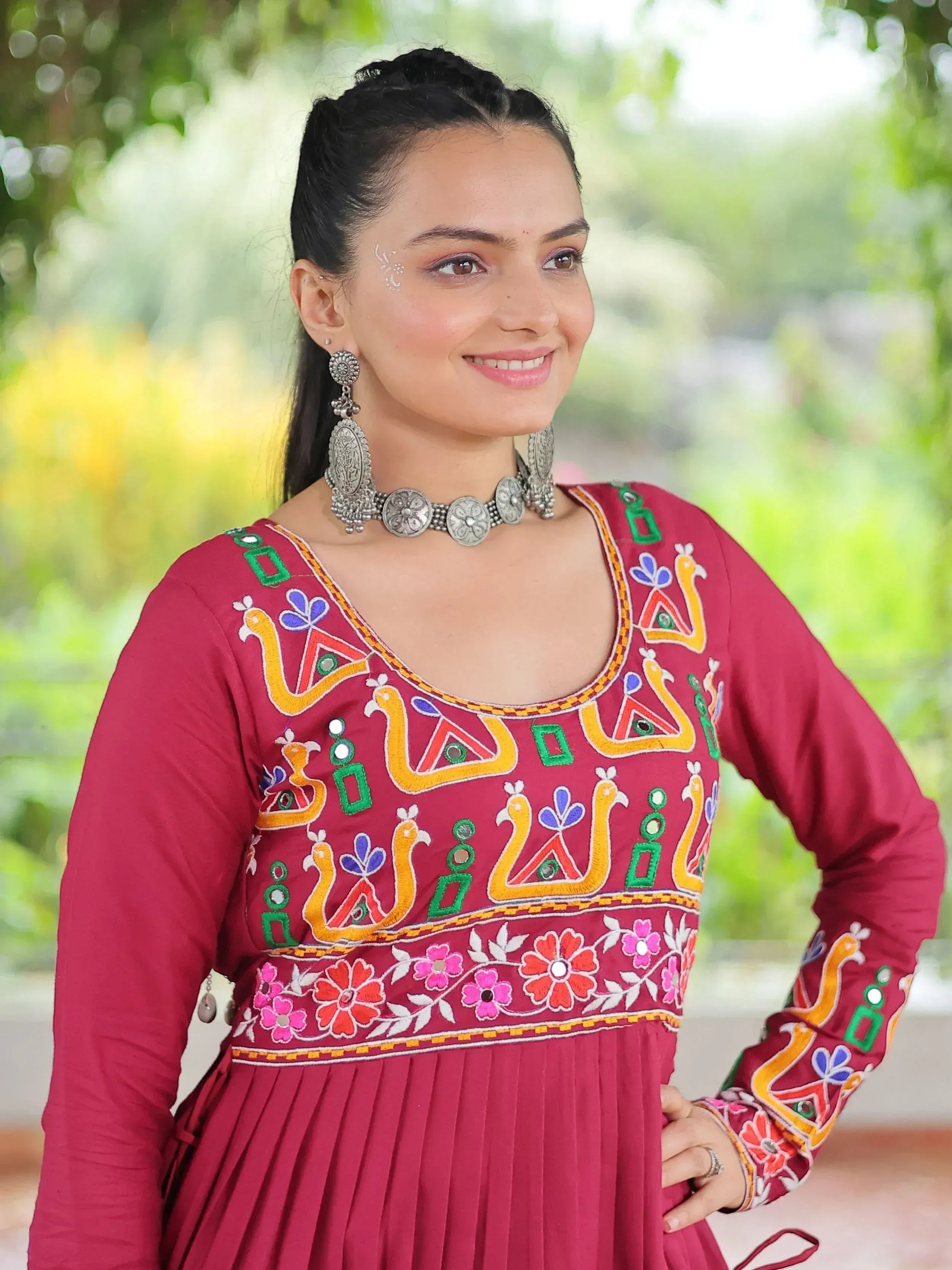Maroon ethnic gown with colorful embroidery and silver jewelry