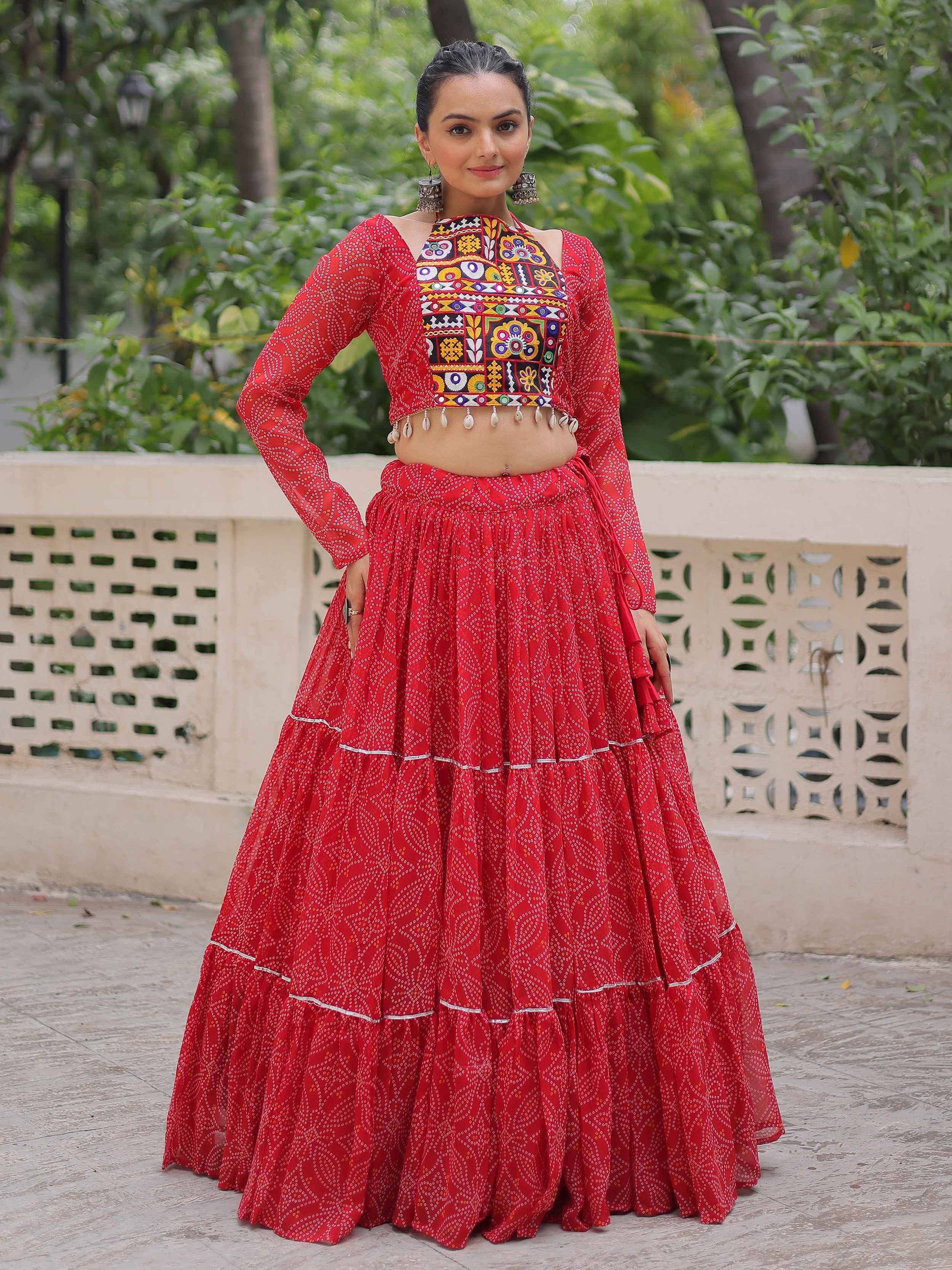 Red ethnic lehenga choli with mirror work and tiered skirt, perfect for Indian festive occasions
