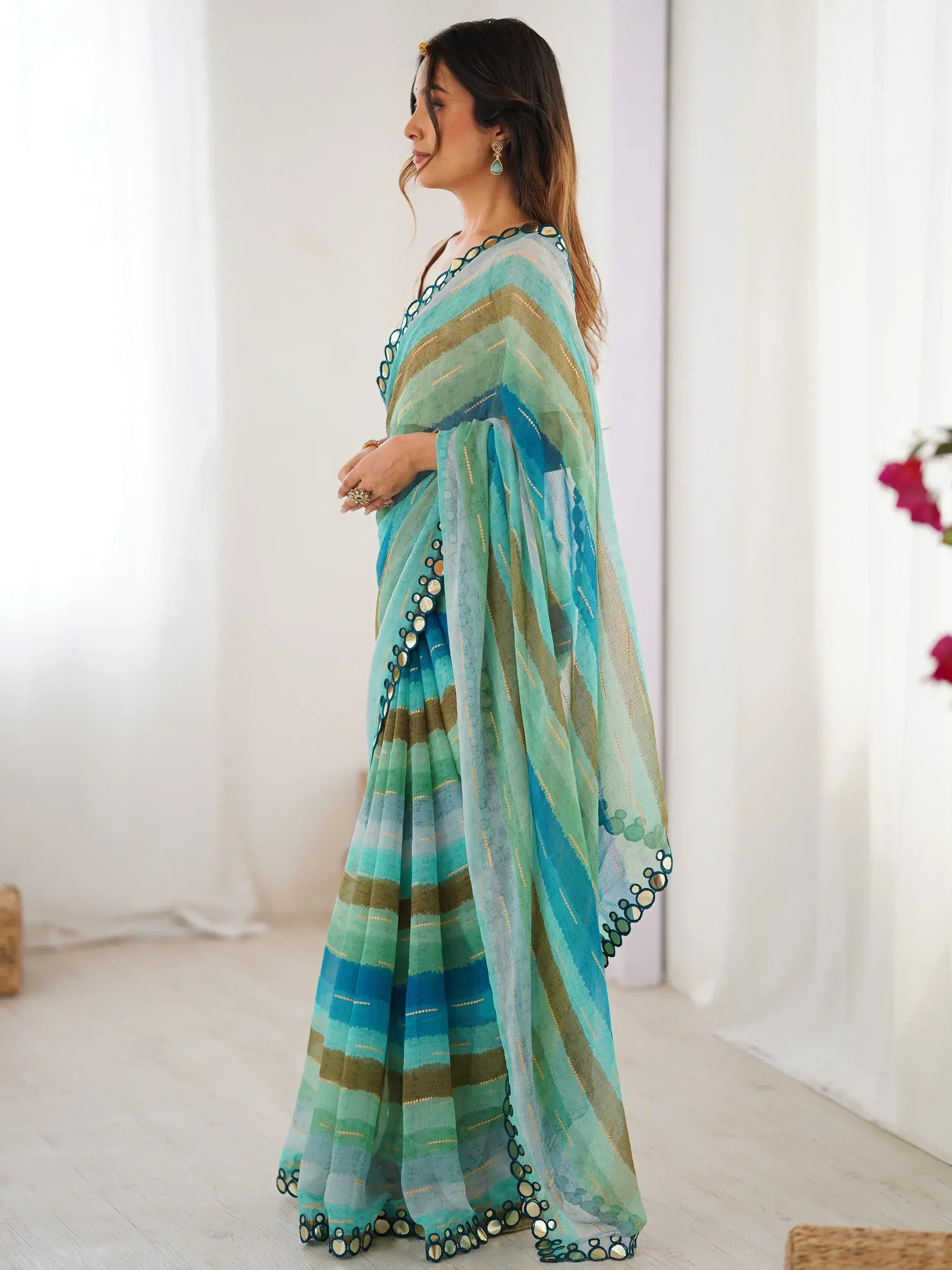 Woman in teal and green striped saree with mirror work, ethnic Indian wear