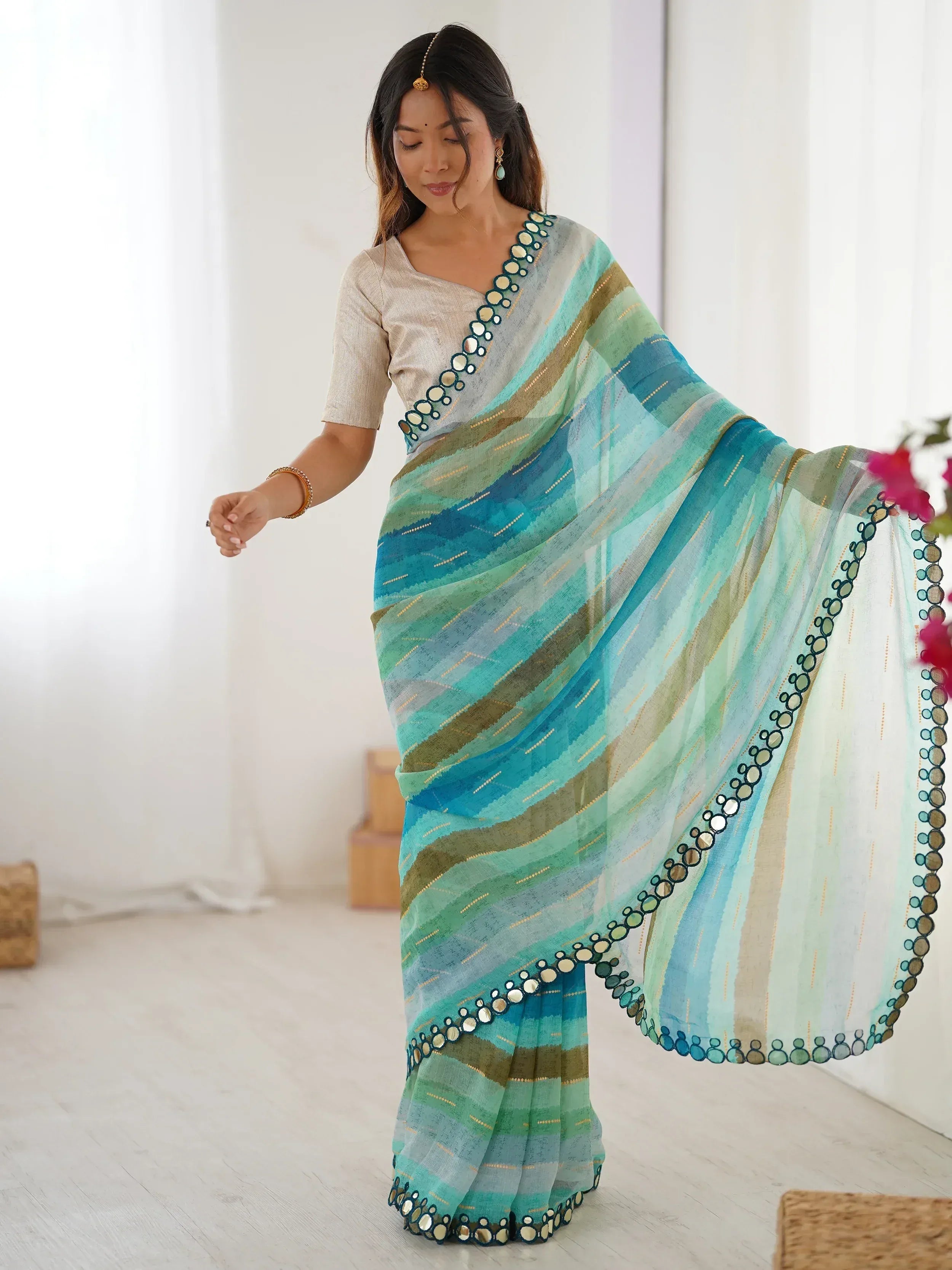 Woman in blue green striped saree with mirror work, ethnic Indian wear for festive occasions