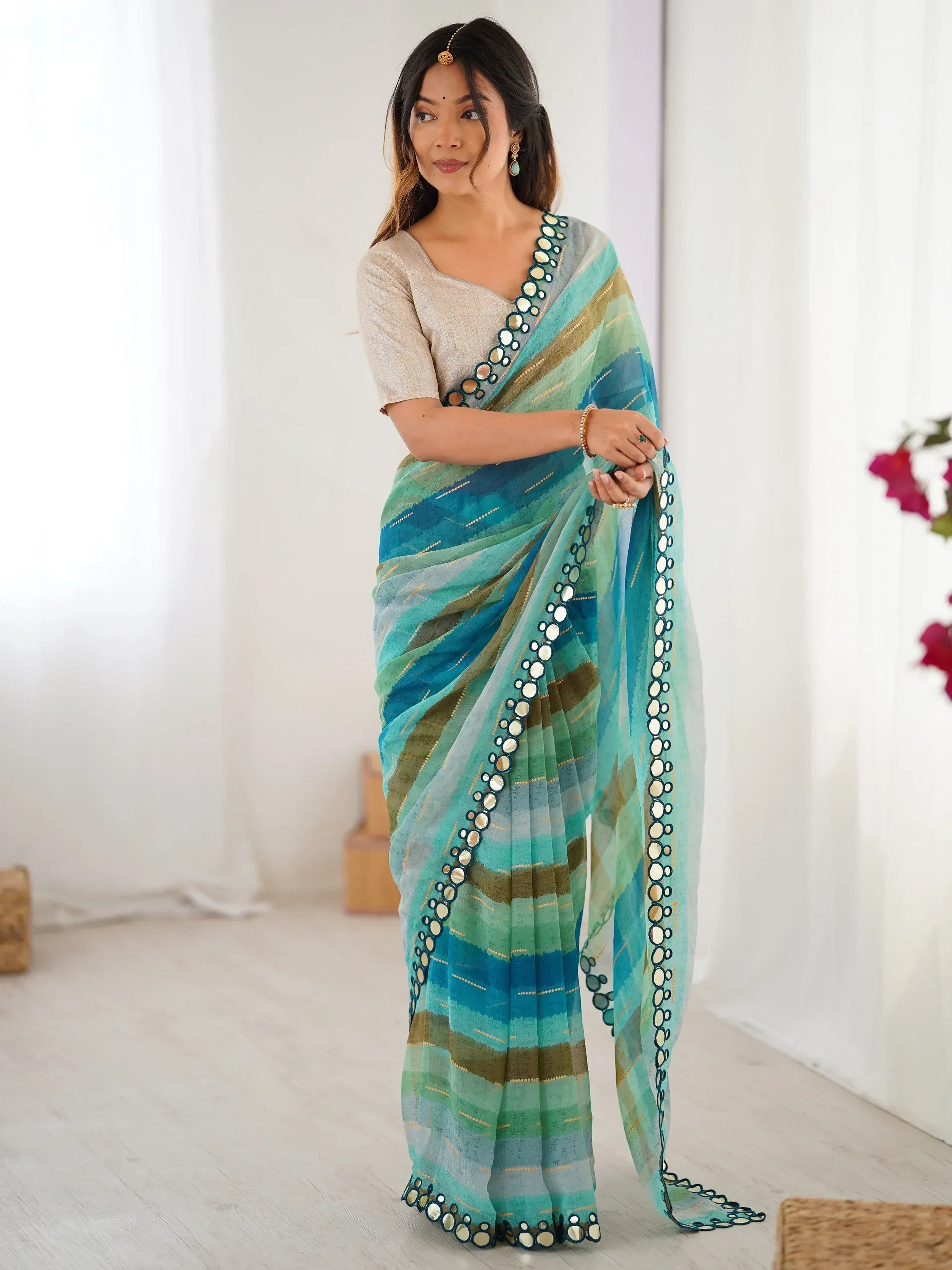 Woman in blue-green striped saree with mirror work, ethnic Indian wear