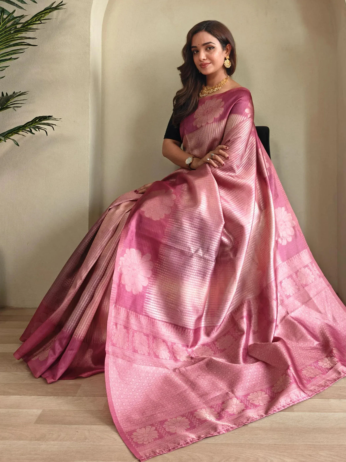 Woman in pink floral designer saree with gold jewelry, ethnic Indian wear
