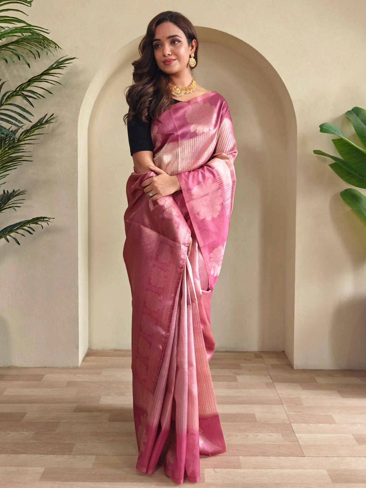 Woman in pink floral designer saree with gold jewelry, elegant ethnic wear for special occasions
