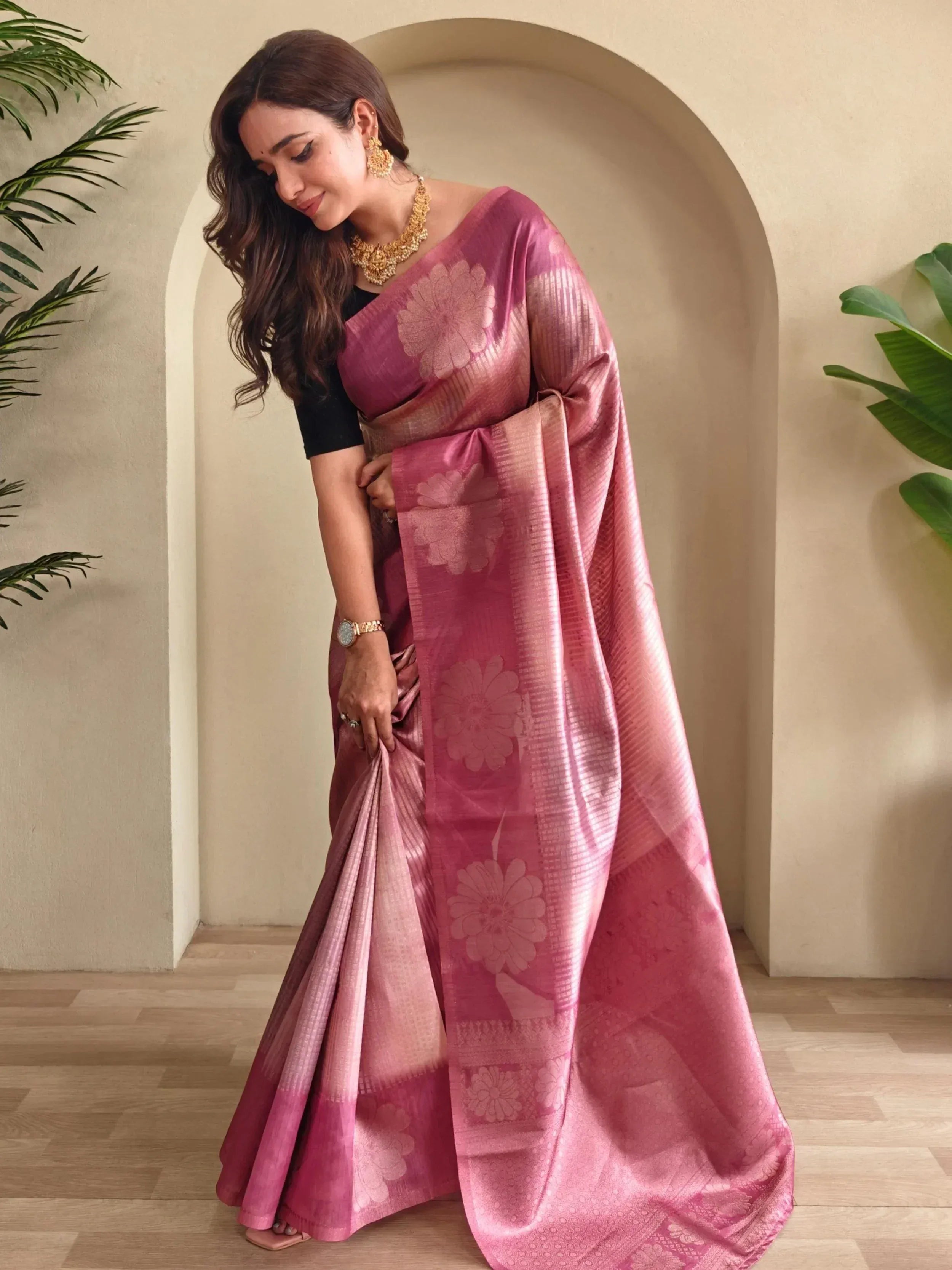 Woman in pink floral designer saree with gold jewelry, ethnic wear for festive occasions