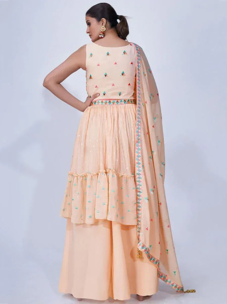 Peach ethnic sharara suit with embroidered top, layered skirt, and matching dupatta for women