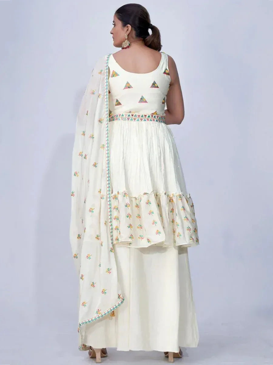 Woman in off-white ethnic lehenga choli with embroidered dupatta and colorful motifs