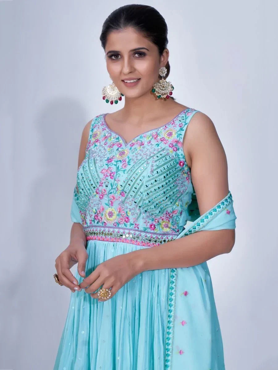Woman in blue embroidered ethnic gown with floral patterns and statement earrings