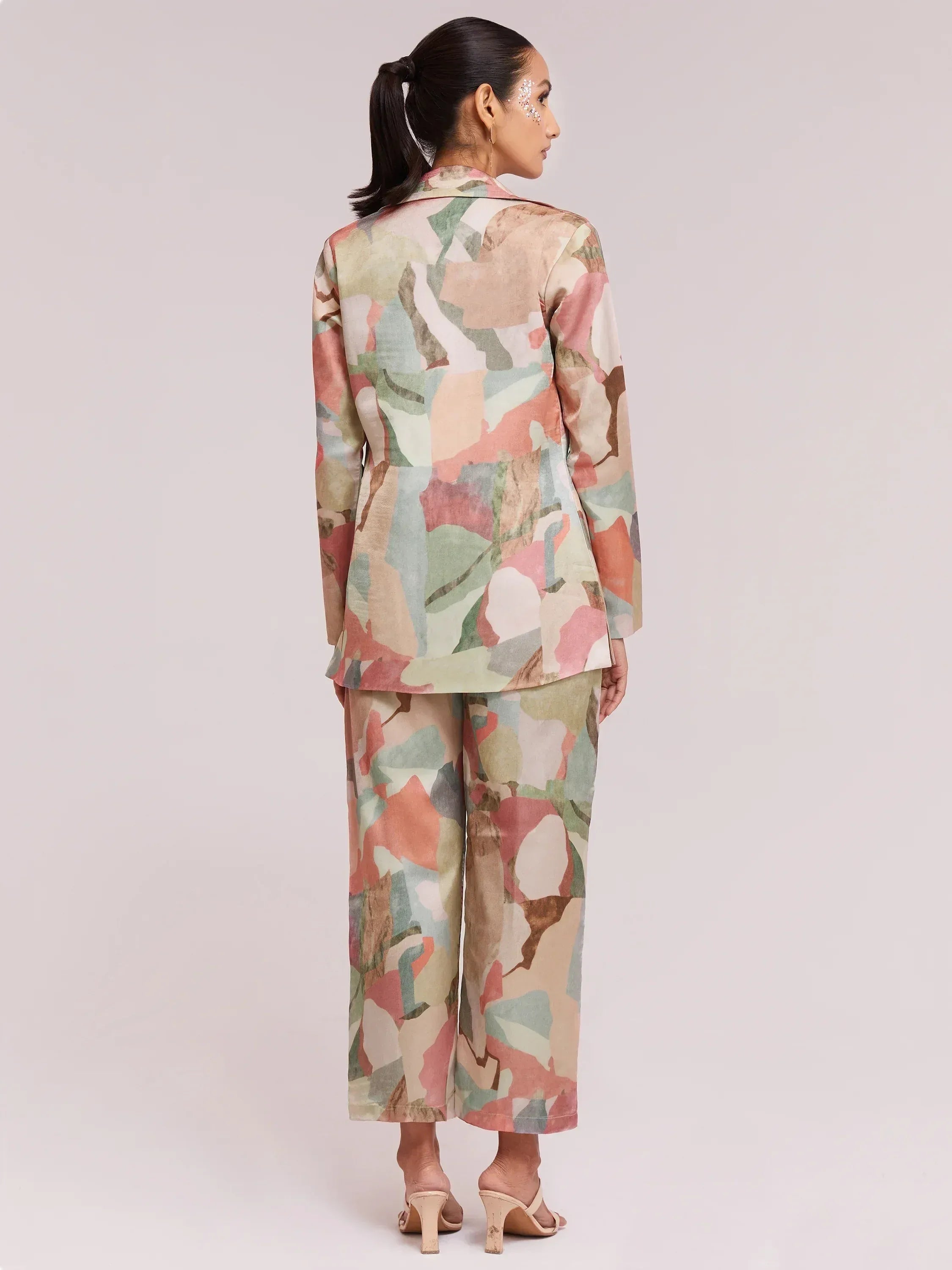 Woman in floral print ethnic suit with blazer and wide-leg pants, back view