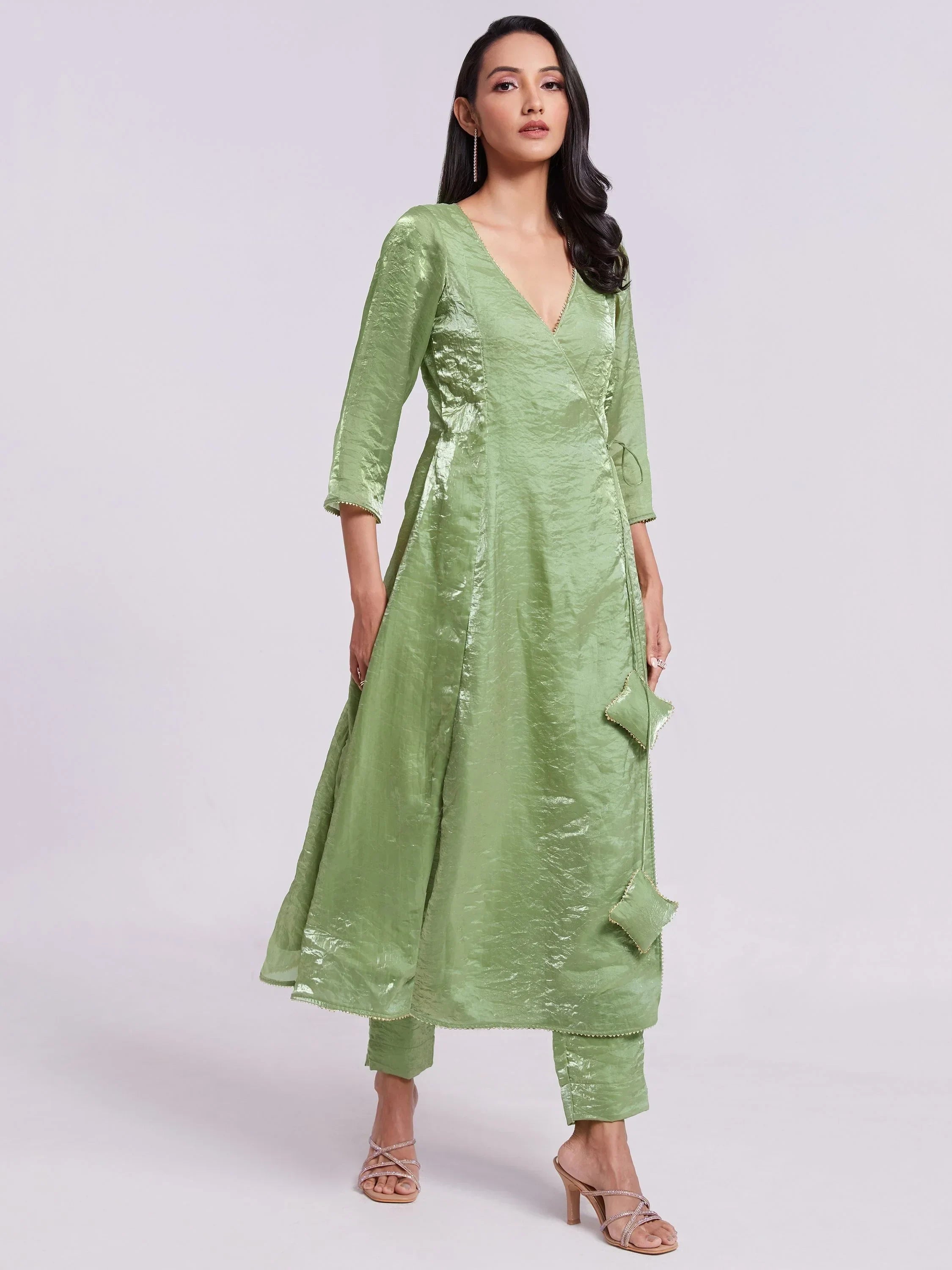 Woman wearing a light green ethnic gown with three-quarter sleeves and matching pants.