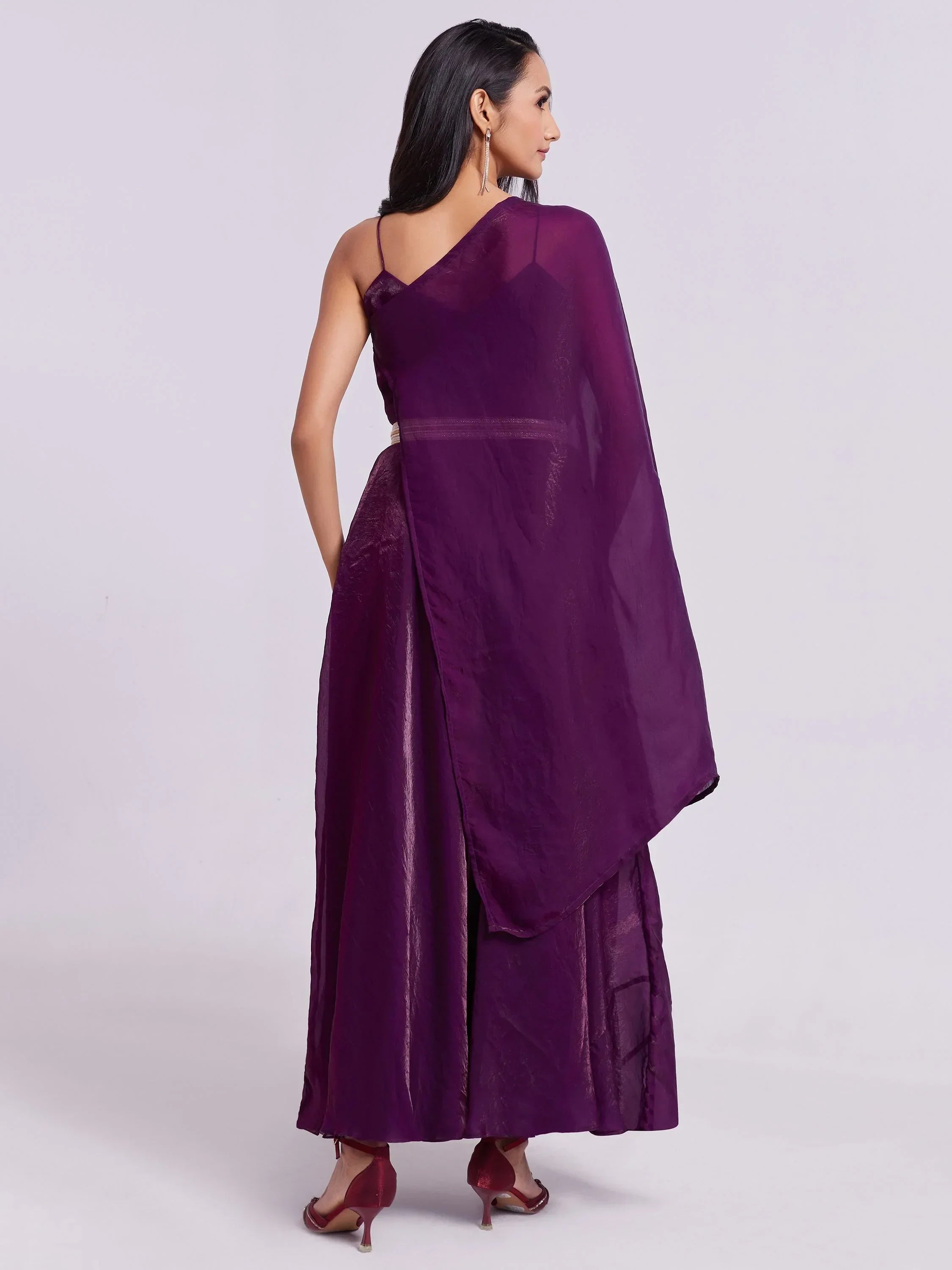 Woman in a stylish purple ethnic gown with dupatta and strappy sleeves, rear view