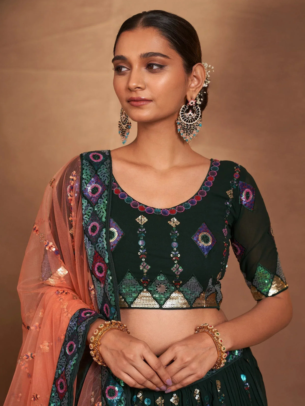 Green sequin embroidered lehenga choli with peach dupatta, perfect for Indian ethnic wear events.
