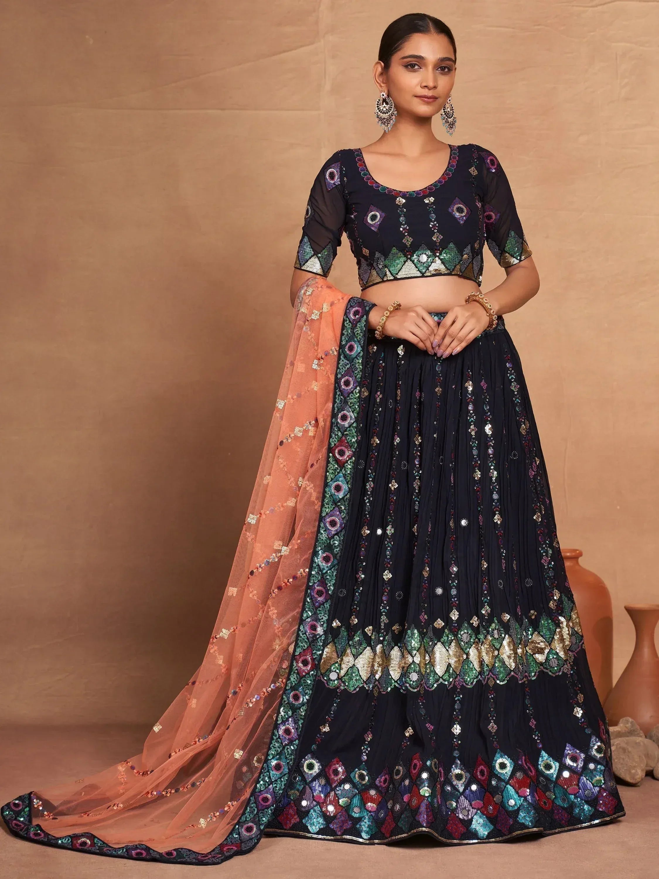 Elegant black designer lehenga choli with colorful embroidery and peach dupatta, perfect for Indian ethnic wear.