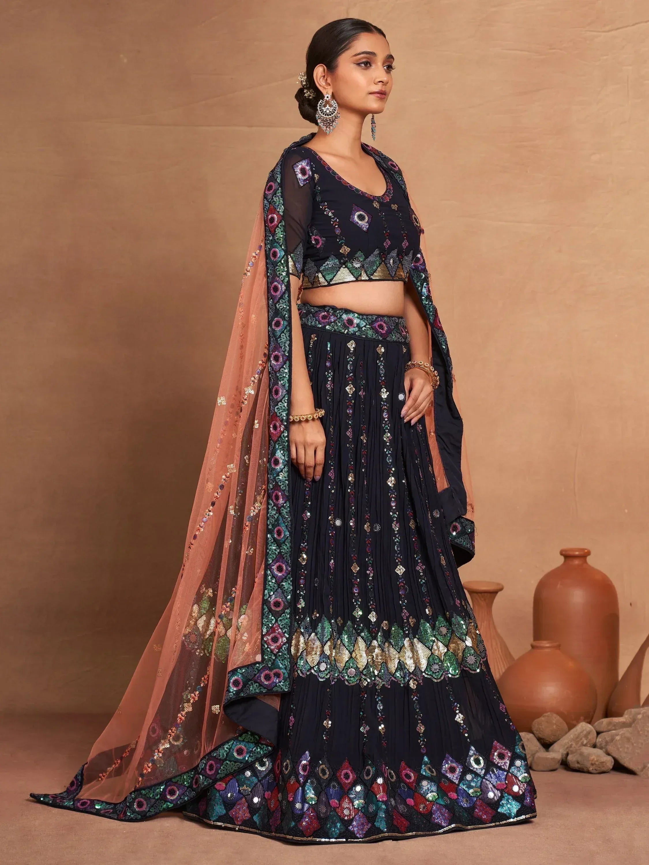 Black embroidered lehenga choli with colorful mirror work and peach dupatta, perfect for Indian ethnic occasions
