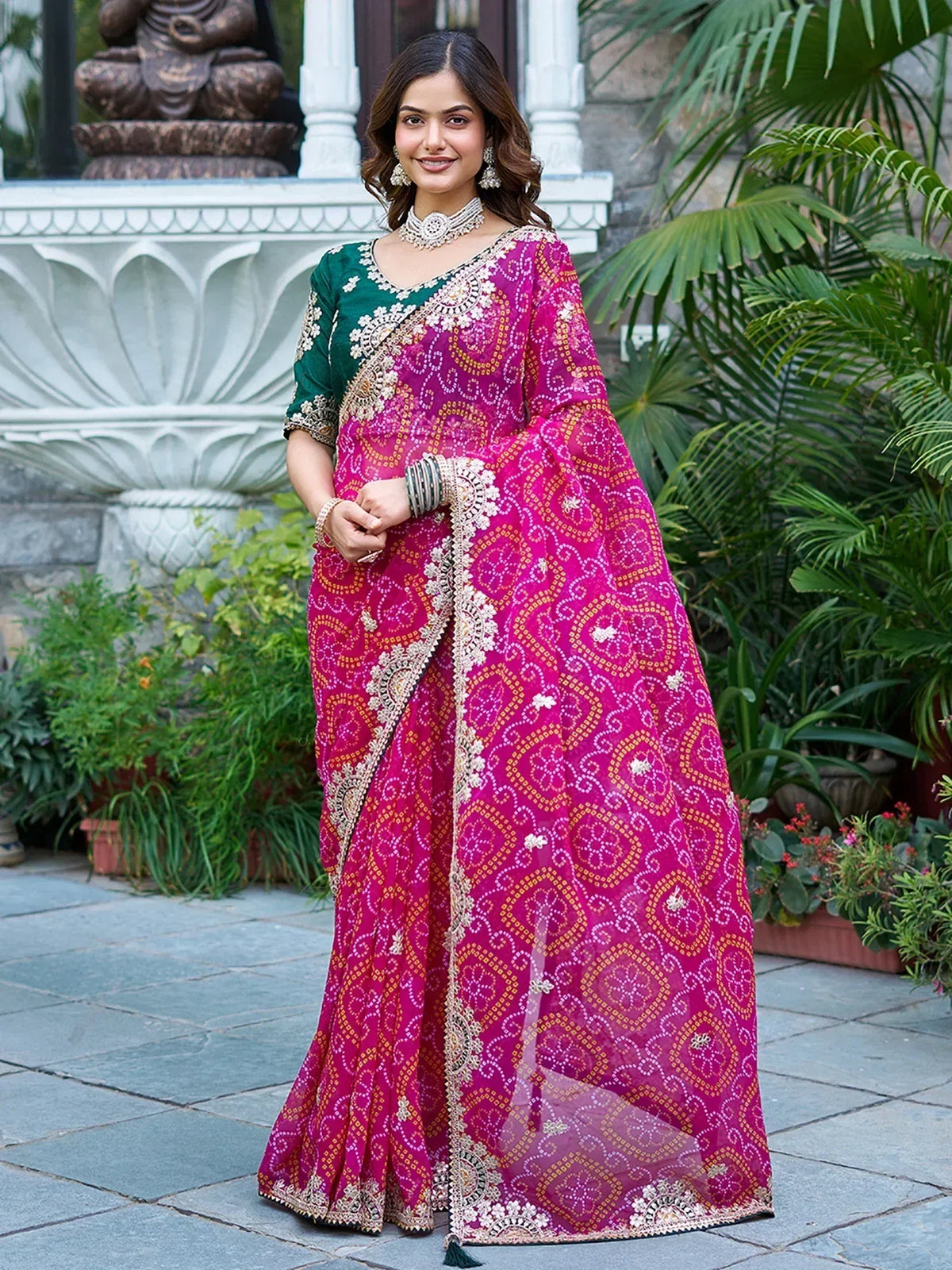 Woman in vibrant pink and green embroidered saree with gold detailing, perfect for Indian ethnic occasions