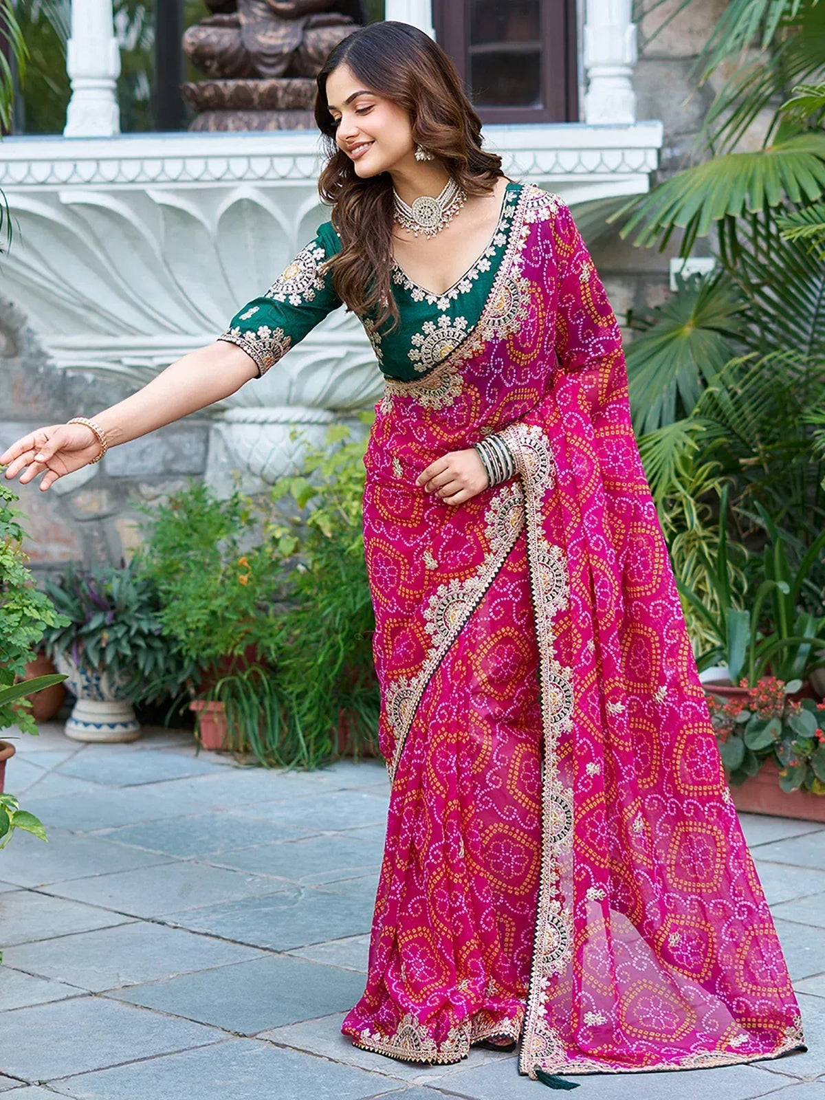 Woman in vibrant pink printed saree with green embroidered blouse, perfect for Indian ethnic occasions