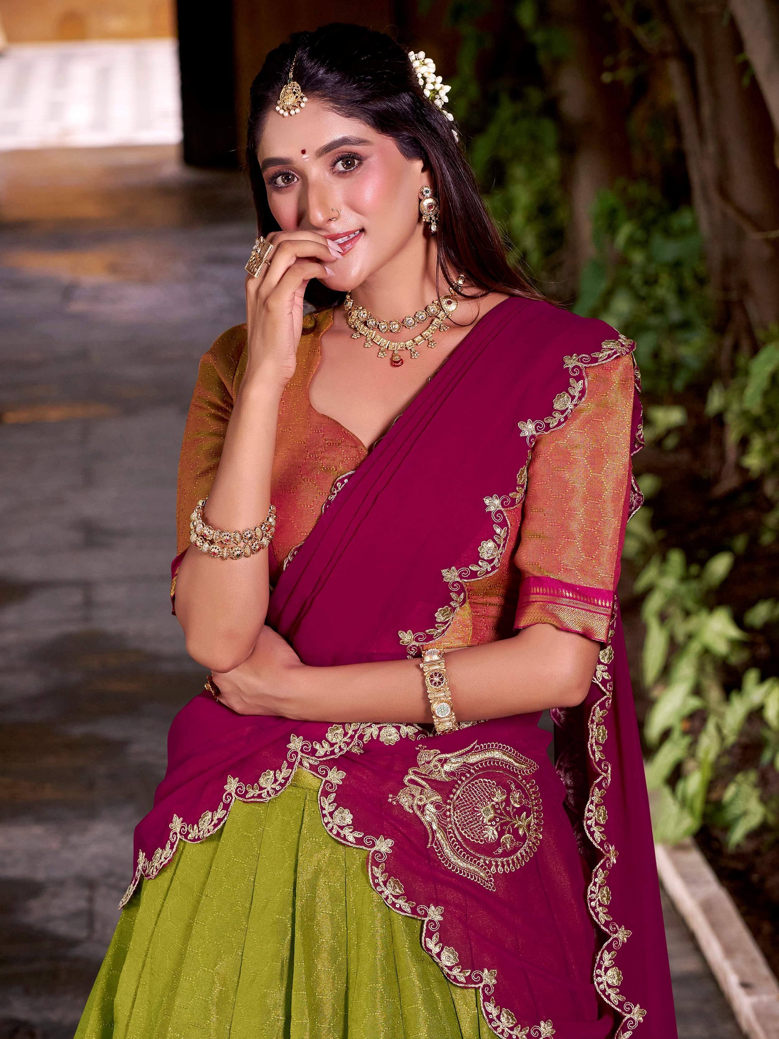 Woman in maroon and green embroidered saree with gold jewelry, traditional Indian ethnic wear