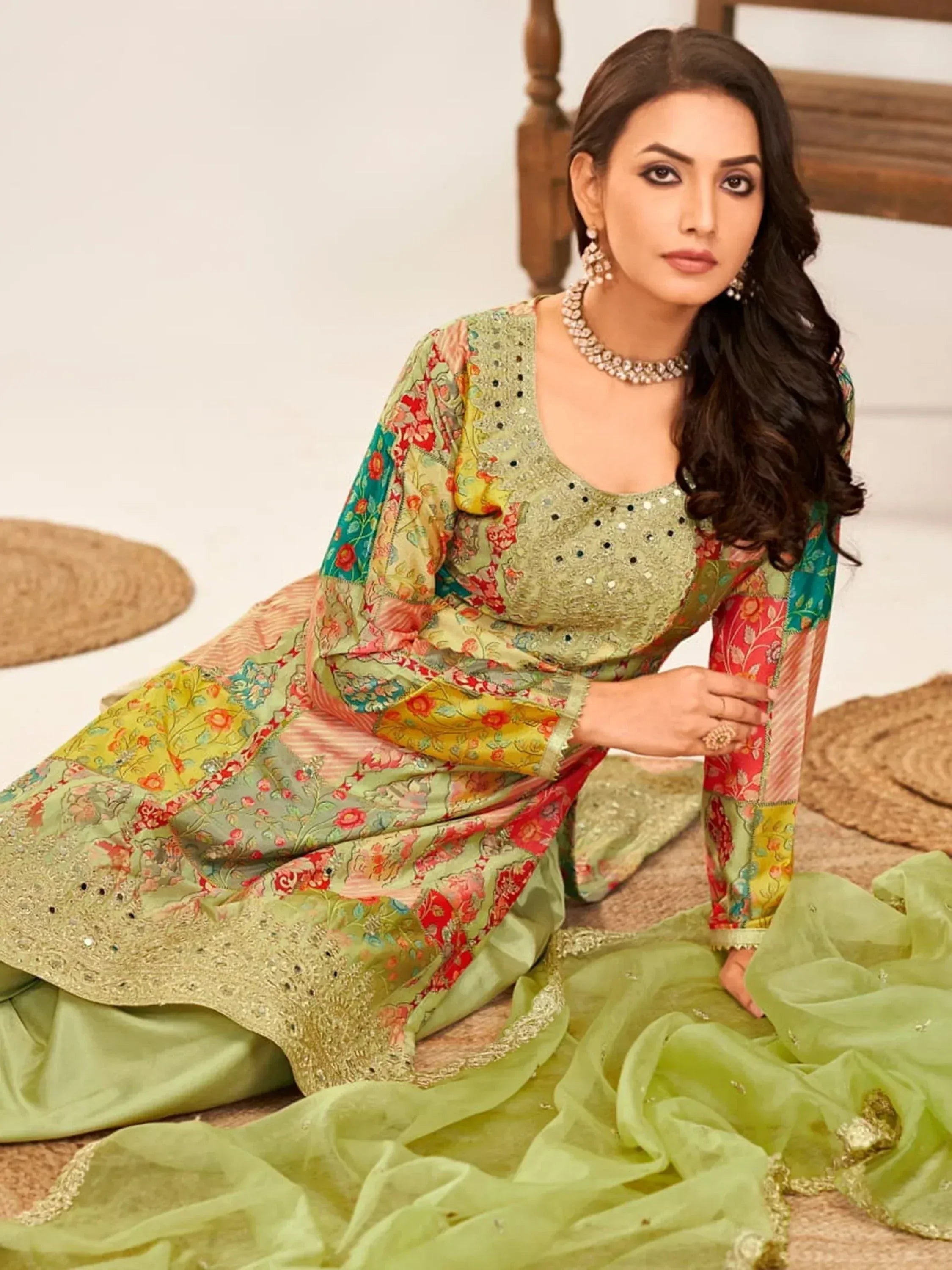 Woman in floral patchwork Indian ethnic gown with sequin embroidery, perfect for festive occasions.