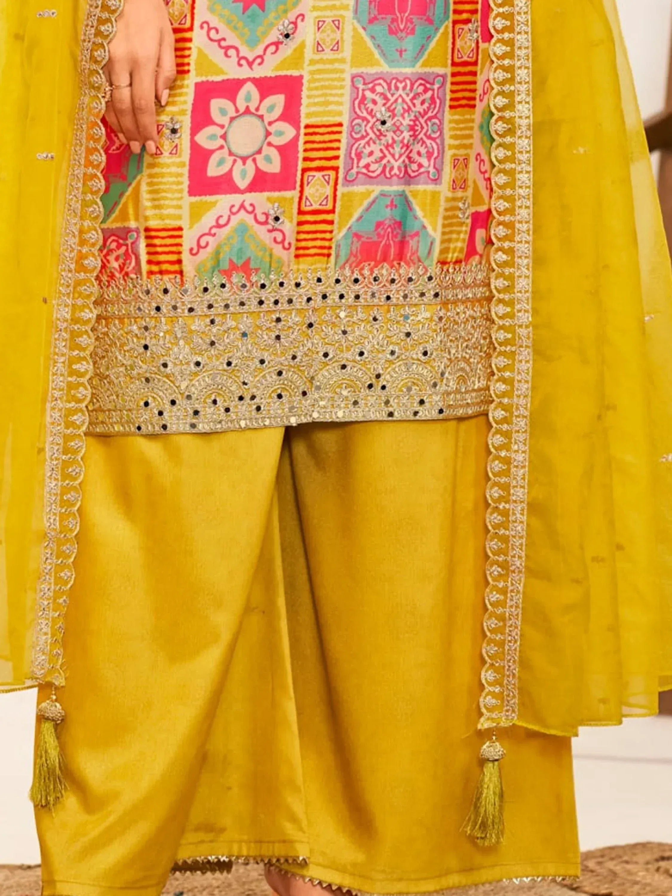 Vibrant yellow ethnic wear with colorful patchwork and intricate embroidery, perfect for festive occasions.