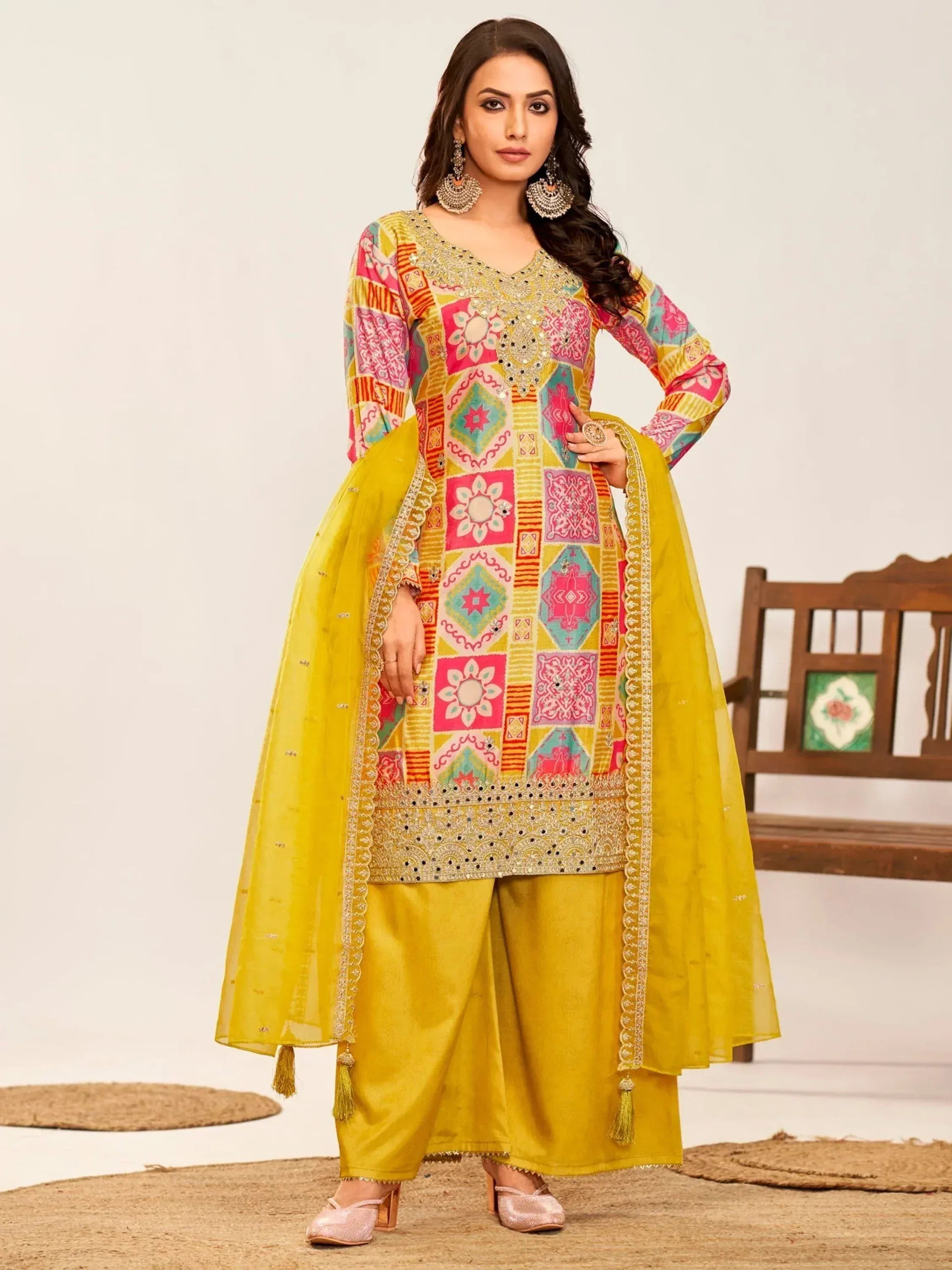 Vibrant yellow salwar kameez with colorful geometric embroidery and matching dupatta for festive occasions